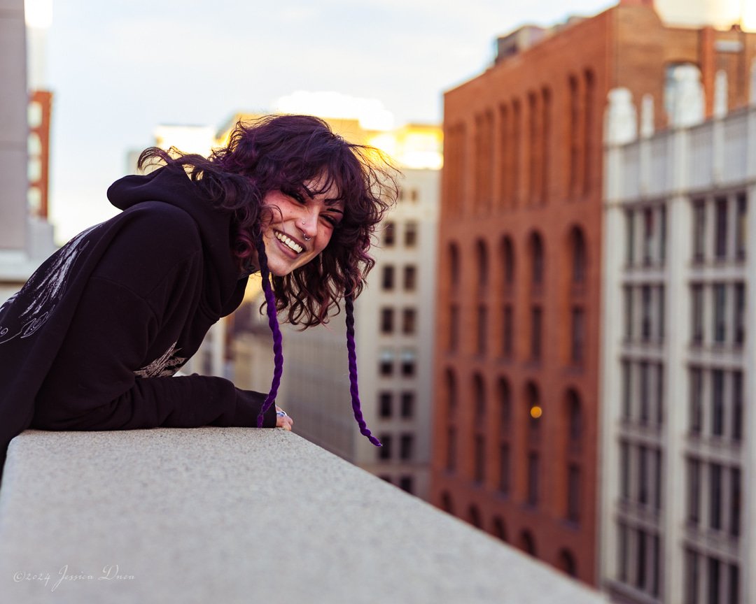 Downtown Denver portrait with candid expression, city architecture, warm evening light, and relaxed posing for creative portraits, branding, and personal photography.