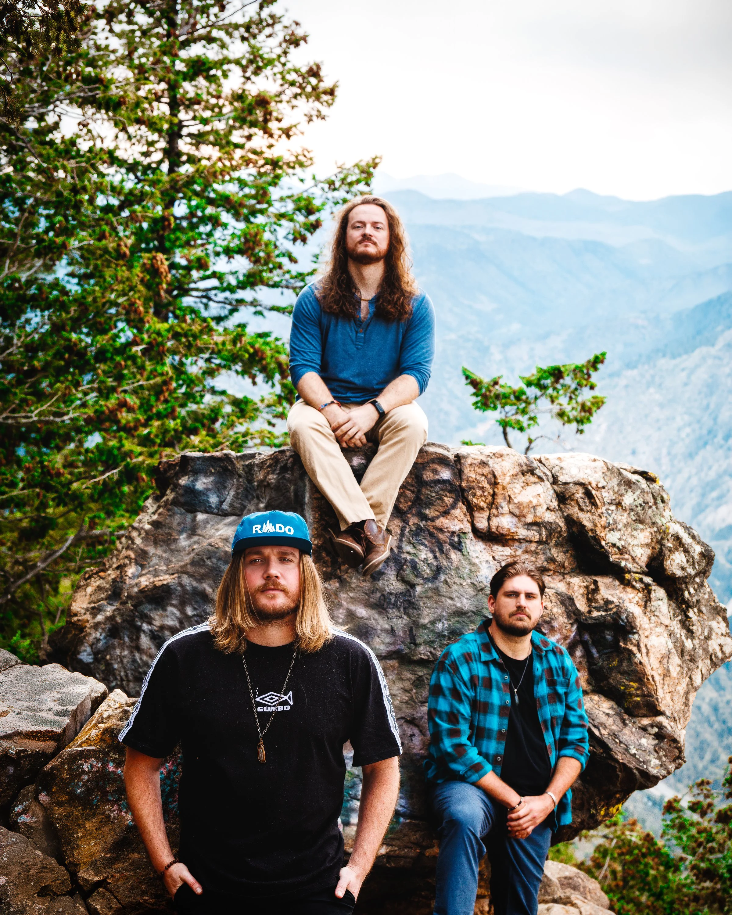 Full-length RADO band portrait arranged among mountain rocks for professional press and promotional use.