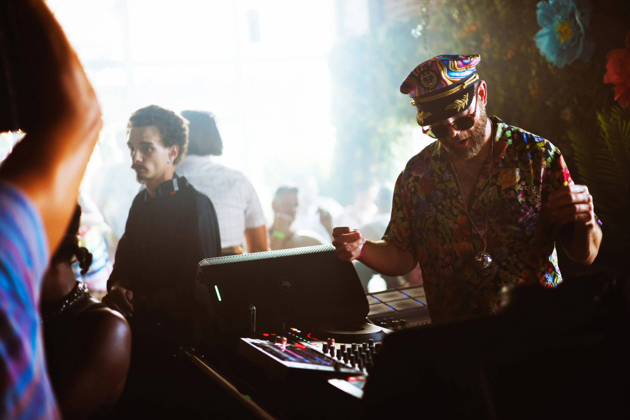 Boogie Lights performs at a brightly backlit DJ booth during a colorful 2026 Denver Pride celebration photographed by Jessica Dnea.