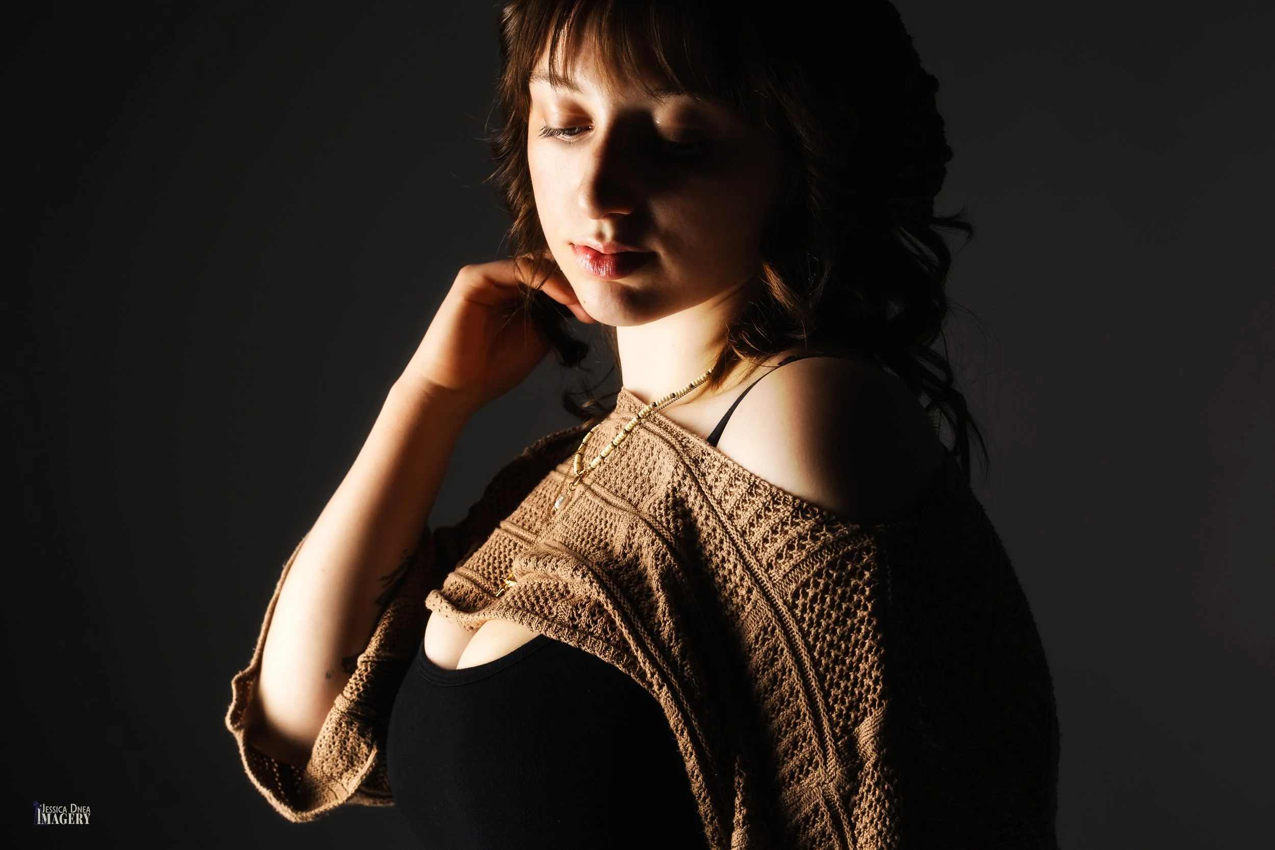 Creative Denver studio portrait with dramatic side lighting, warm tones, soft expression, and editorial styling for personal portraits, artist branding, and professional use.