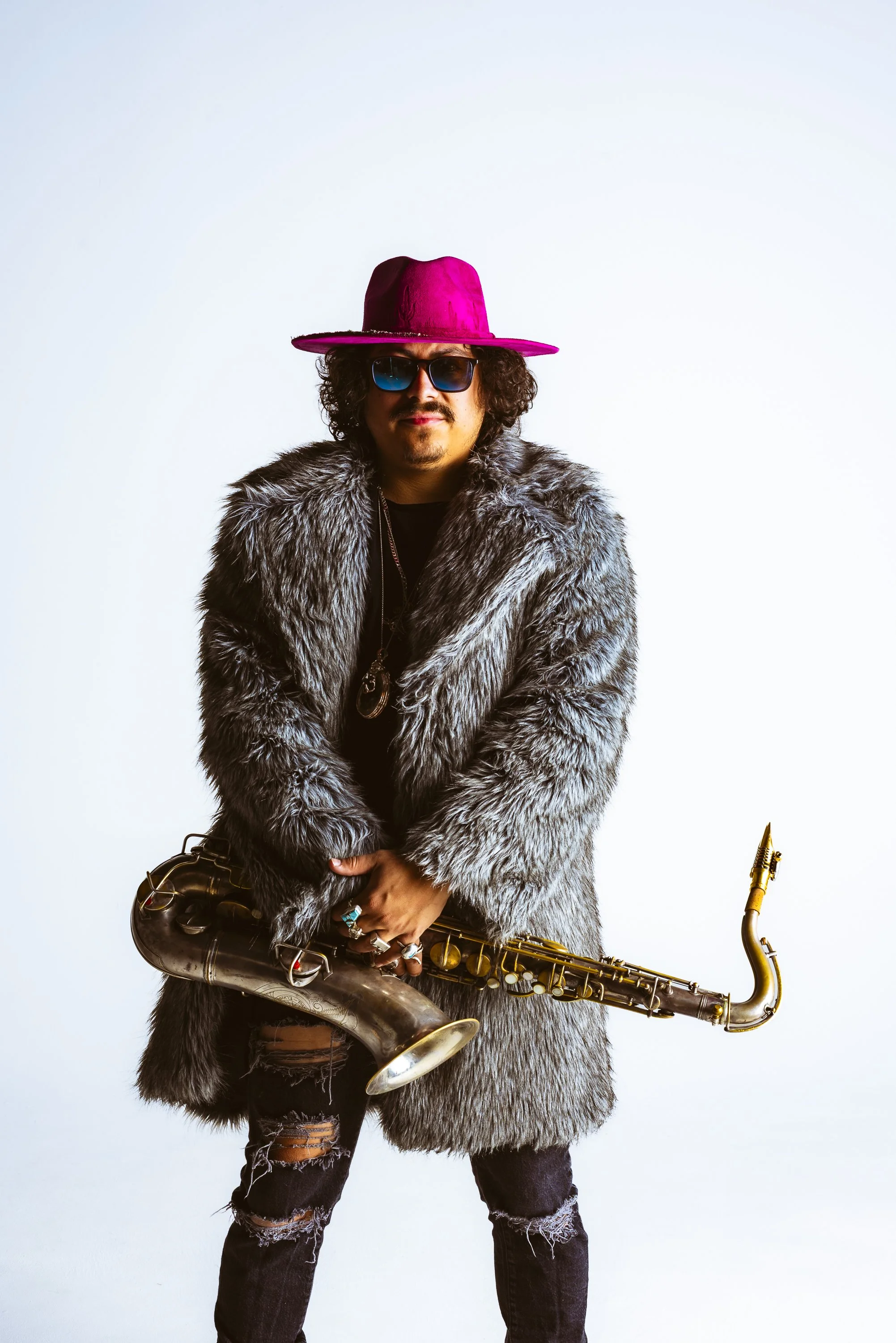 Clean white cyc portrait of a saxophonist created as flexible source material for press and graphic design.
