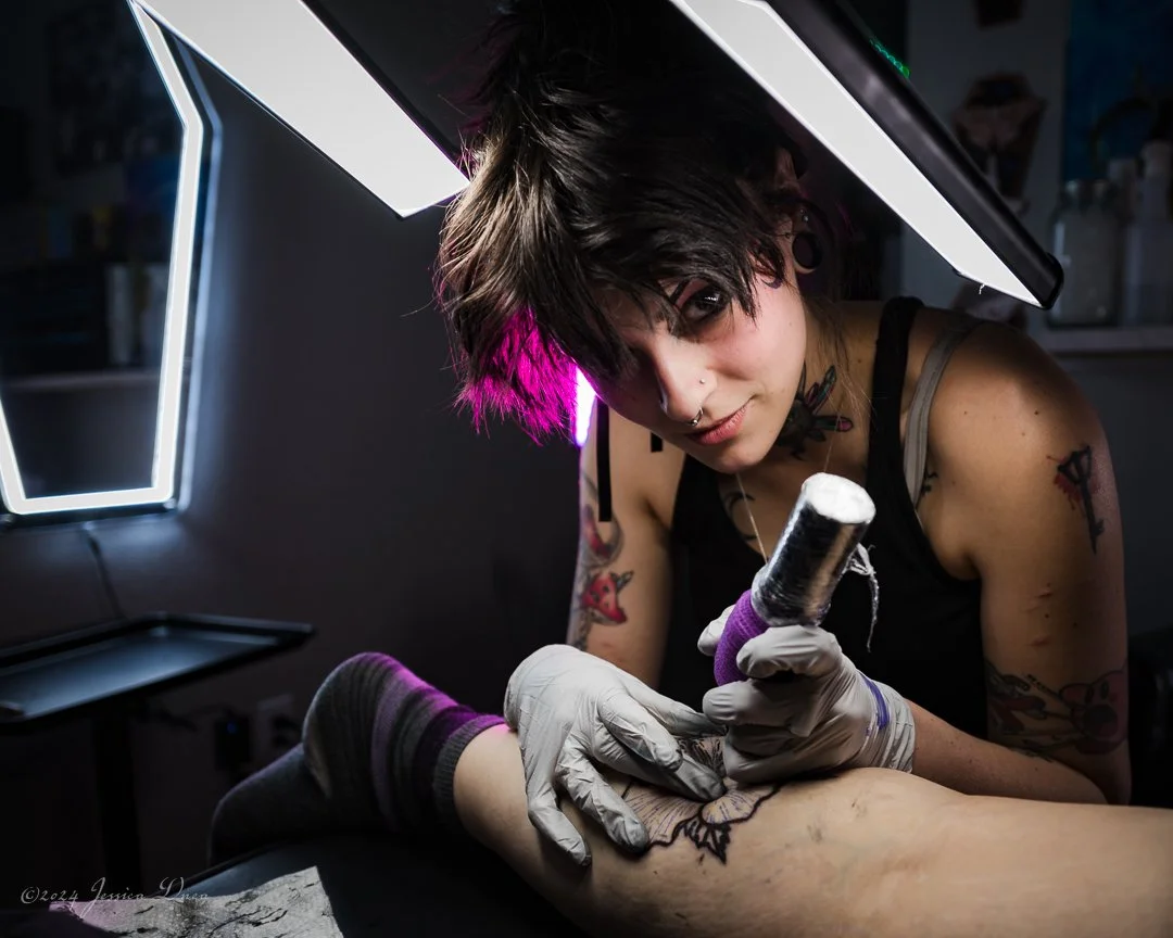 Denver personal branding photography for a tattoo artist working with a client, showing the artist, tools, workspace, and real service experience for business websites and social media.