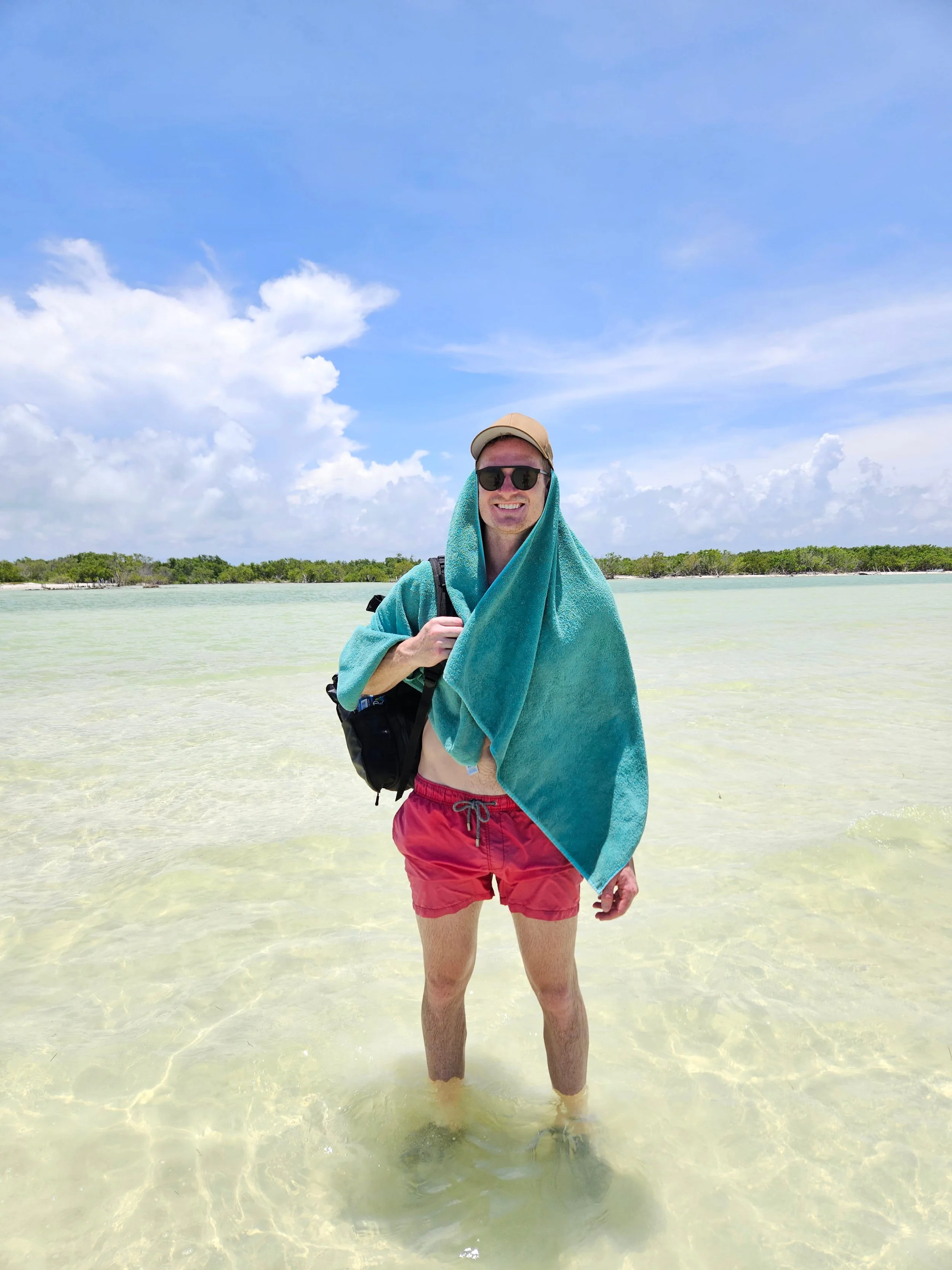 Couple walking in water to see Flamingos standing in shallow water near Holbox