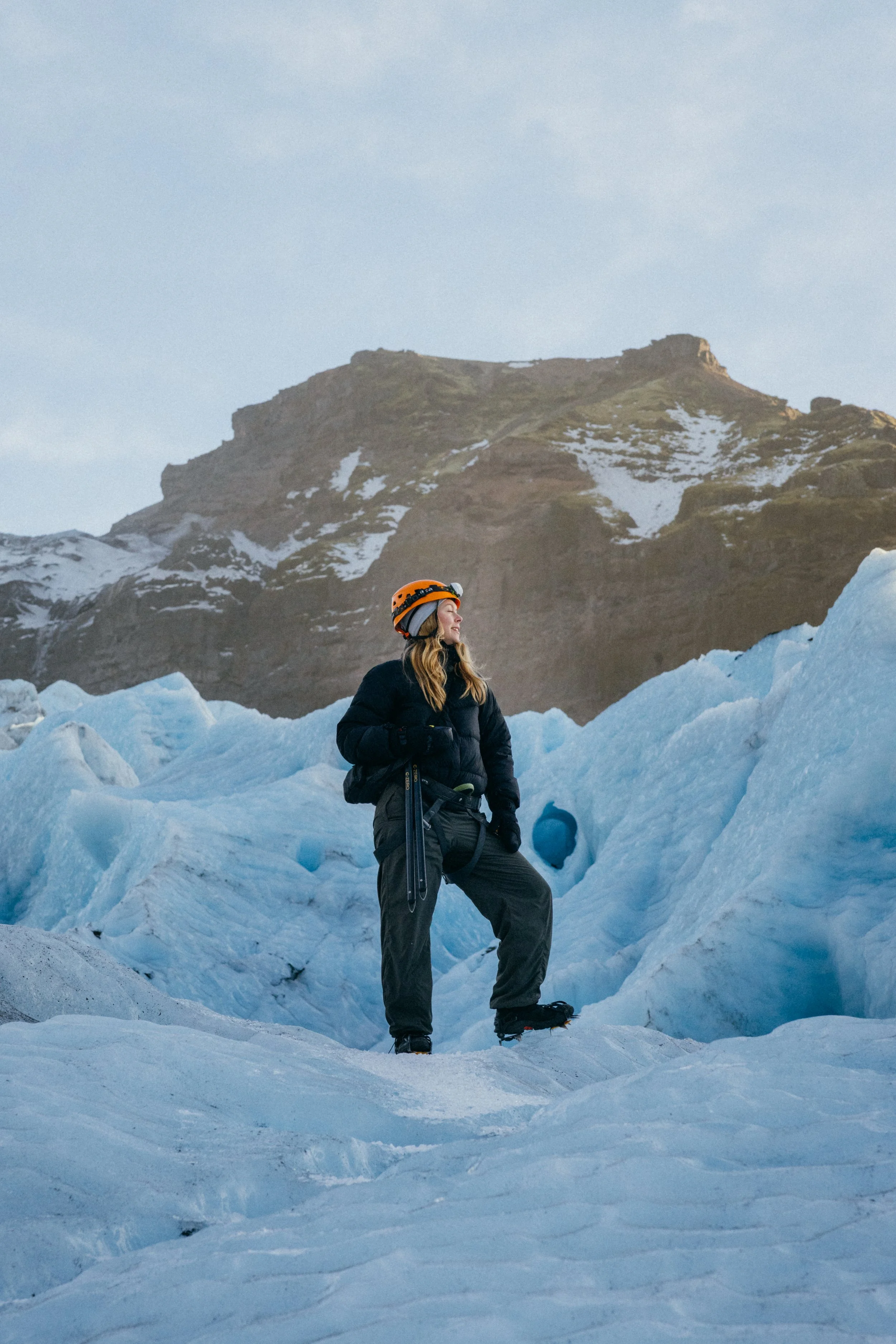 Travelers hiking across icy terrain on a glacier in Iceland