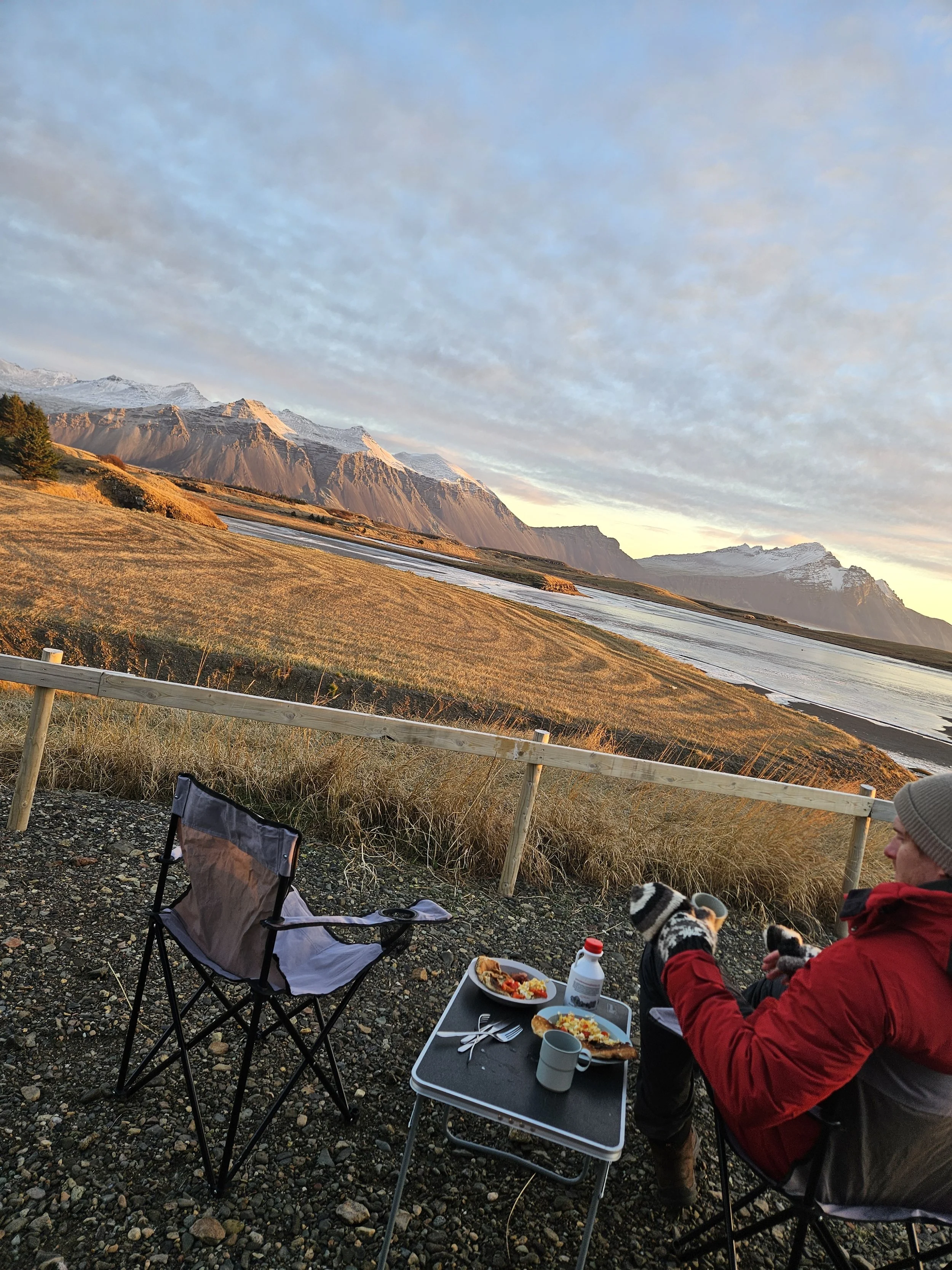 Couple stopping to enjoy breakfast and view of moutains during Iceland campervan trip