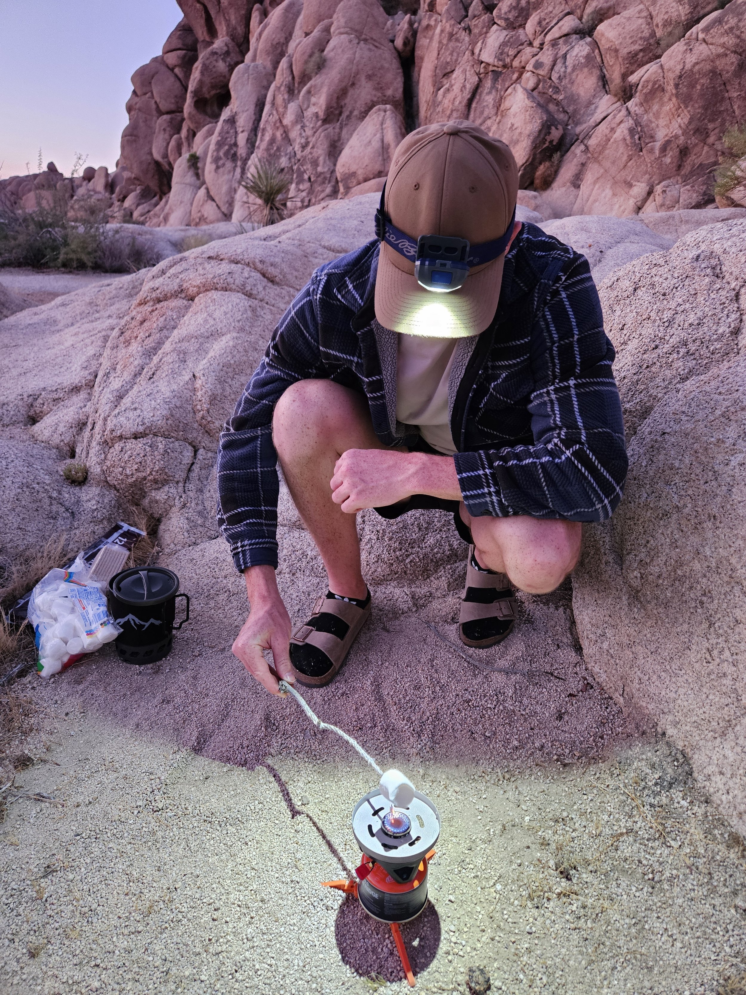 couple roasting marshmallow on a fire at their campsite in Joshua Tree National Park