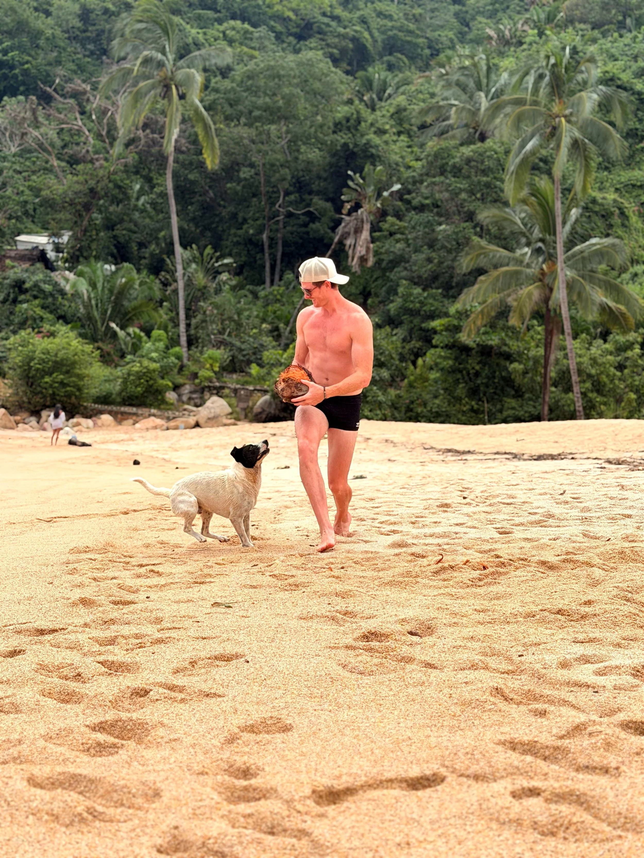 man playing with dog on the beach in yelapa mexico