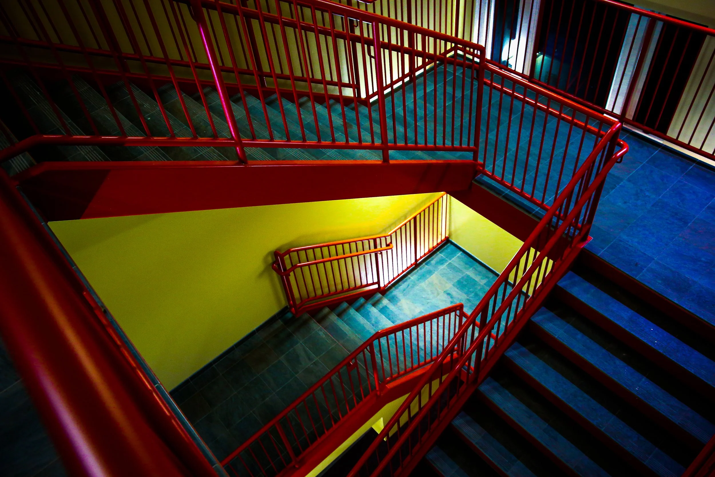 Colorful stairwell with red railings and yellow walls