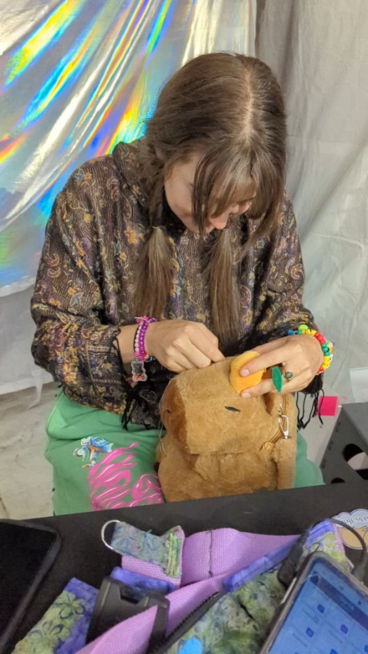The little tangerine on my capybara backpack only survived one night at @libfestival before falling off&mdash;turns out it was barely hanging on by a single thread! Thankfully, @briehirsh at the FrankenBois booth came to the rescue and securely reatt