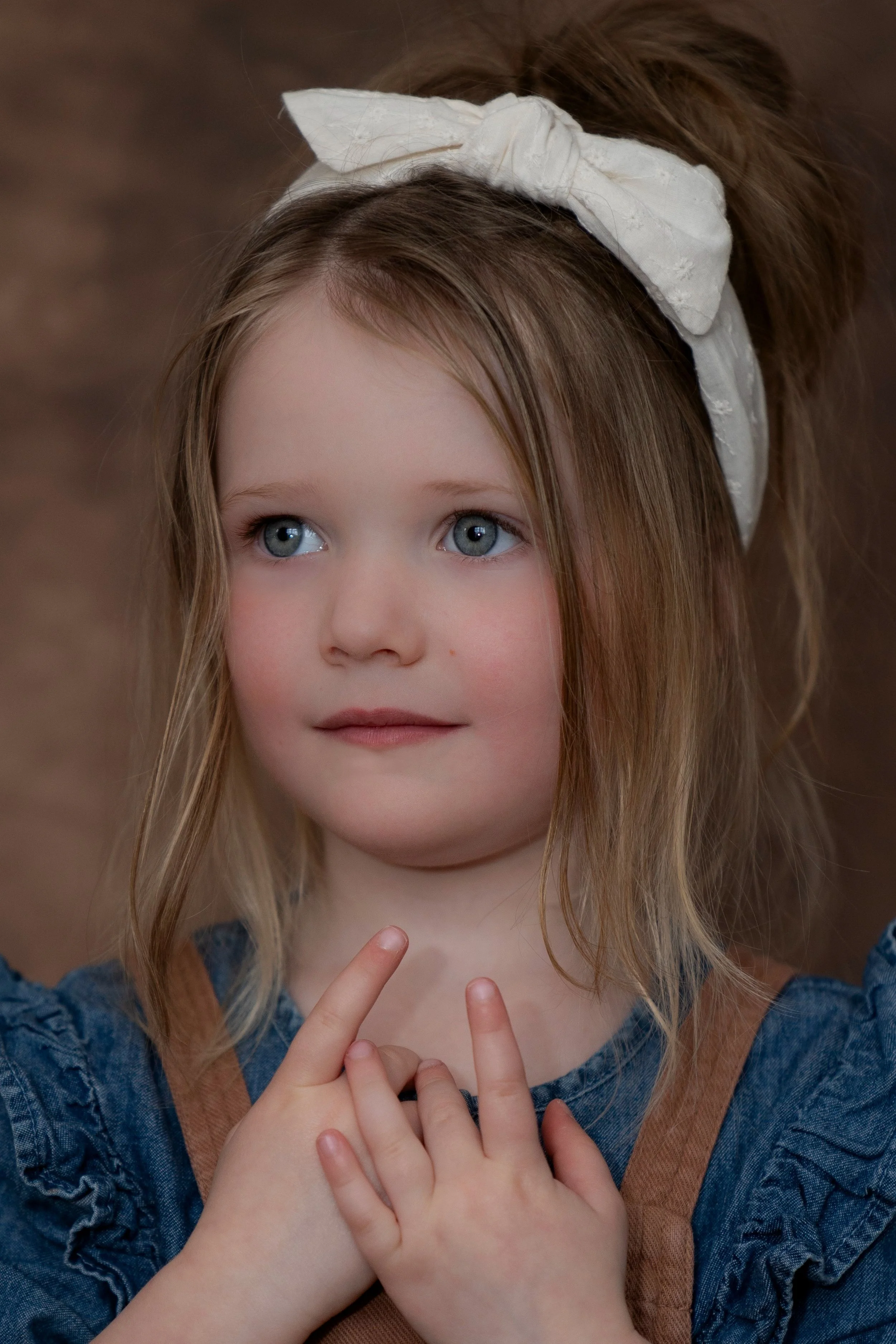 Onportrait fotografie. Prachtig kinderportret met een bruine achtergrond.jpg