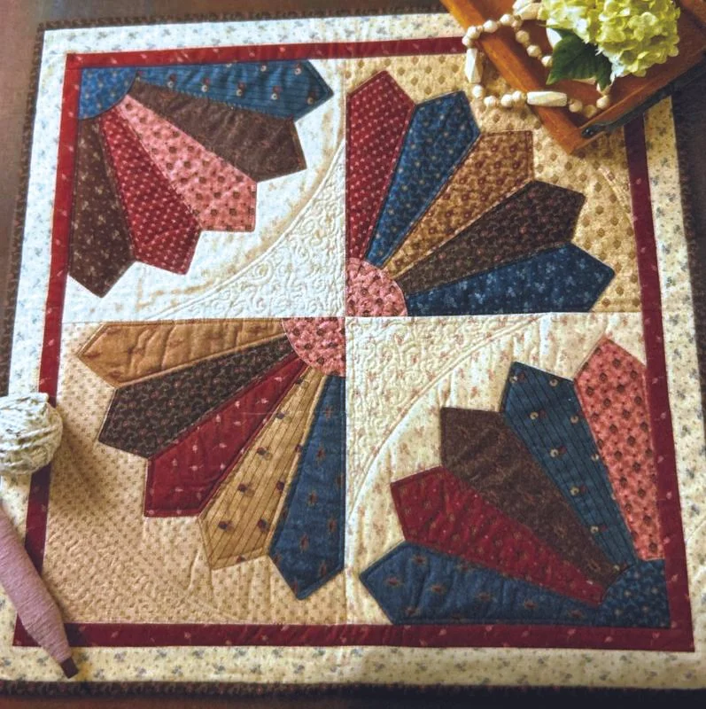 Fan-style quilt block made from cut fabric pieces, assembled into a decorative quilt project using a die cutting machine.