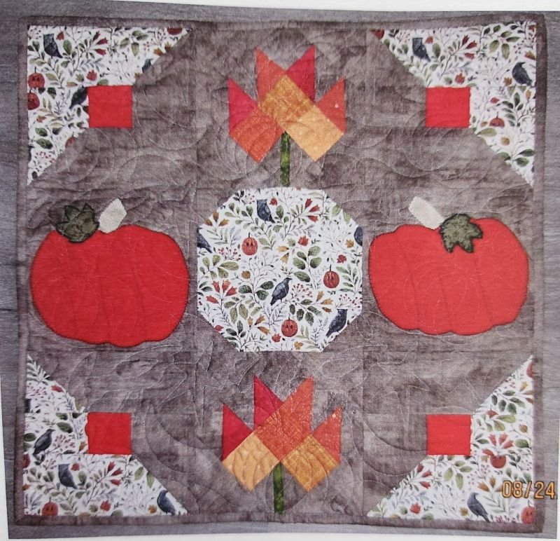 Handmade pumpkin-and-leaf-themed fabric banner or wreath designed for seasonal wall or door décor.