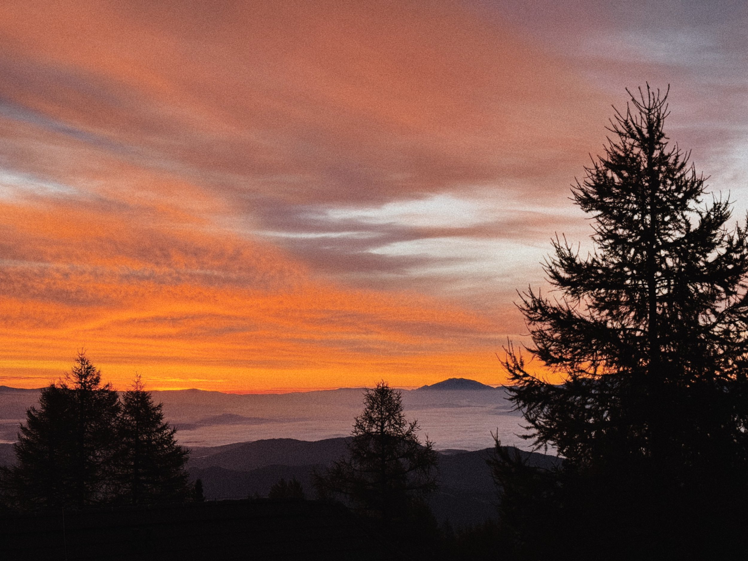 sonnenaufgang mit rotem himmel über einer geschlossenen wolkendecke auf der gerlitzen alpe am feuerberg in kärnten