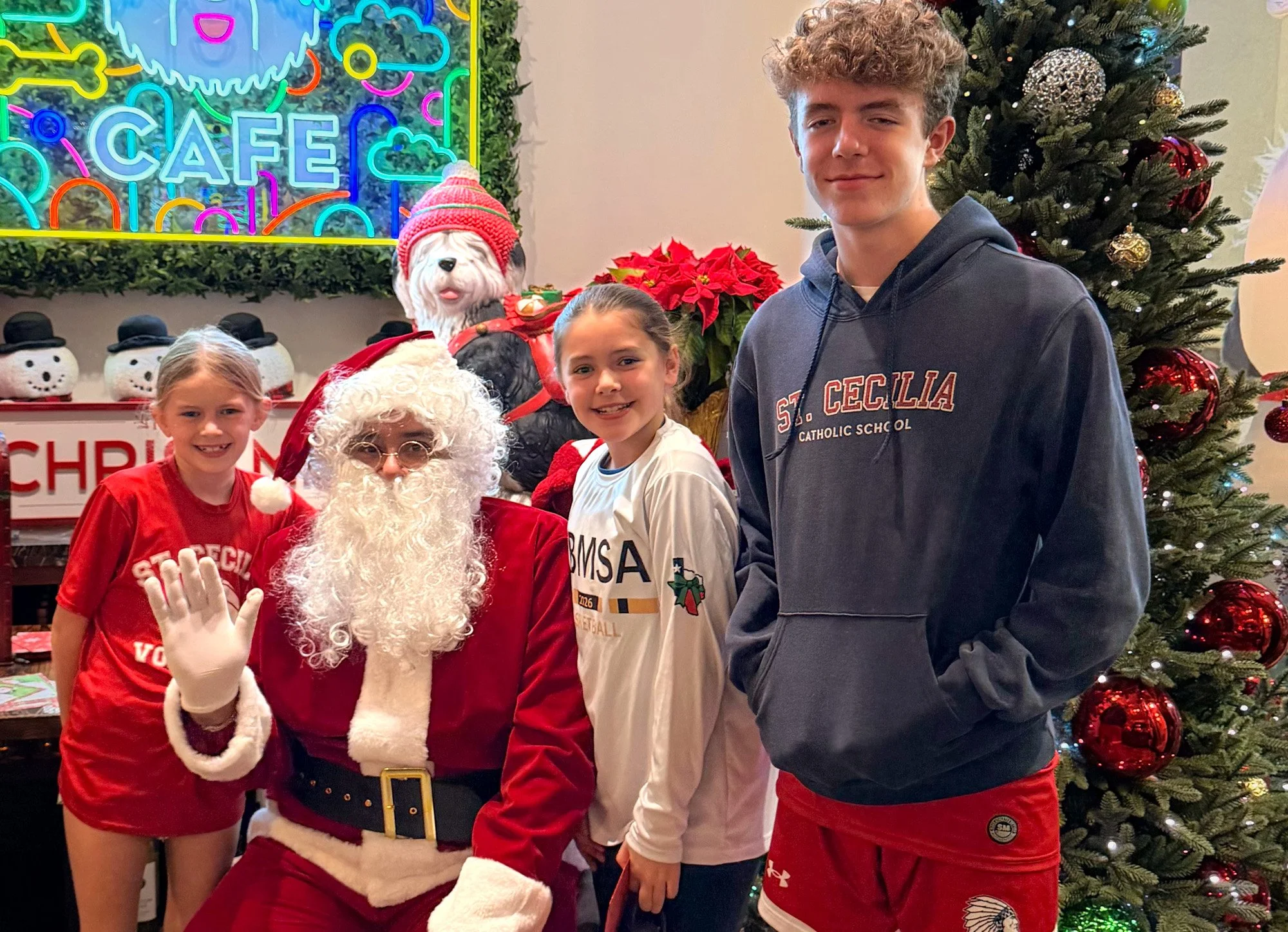 Group of children with Santa Claus, a Christmas tree, and holiday decorations.