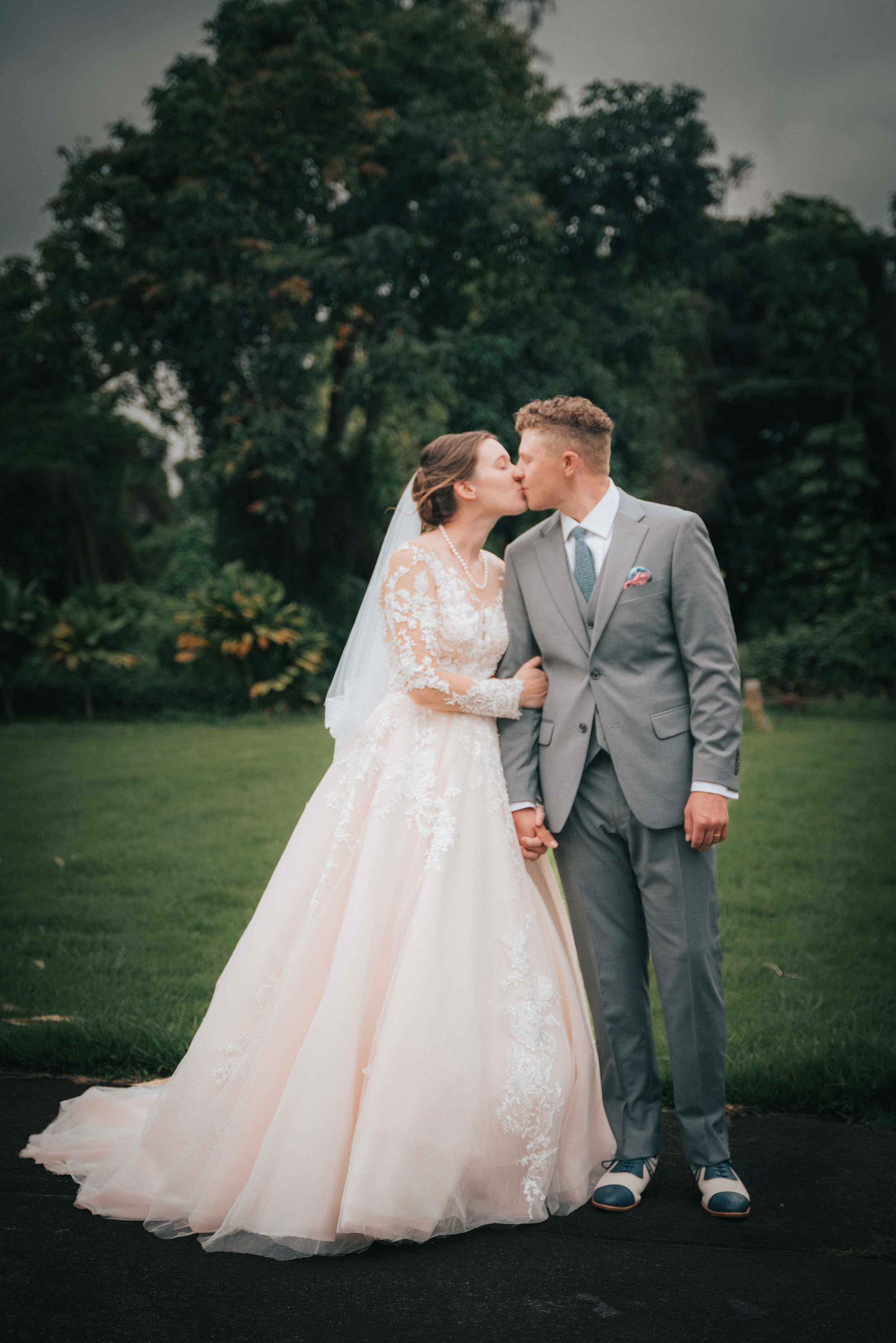 Bride and groom kissing outdoors