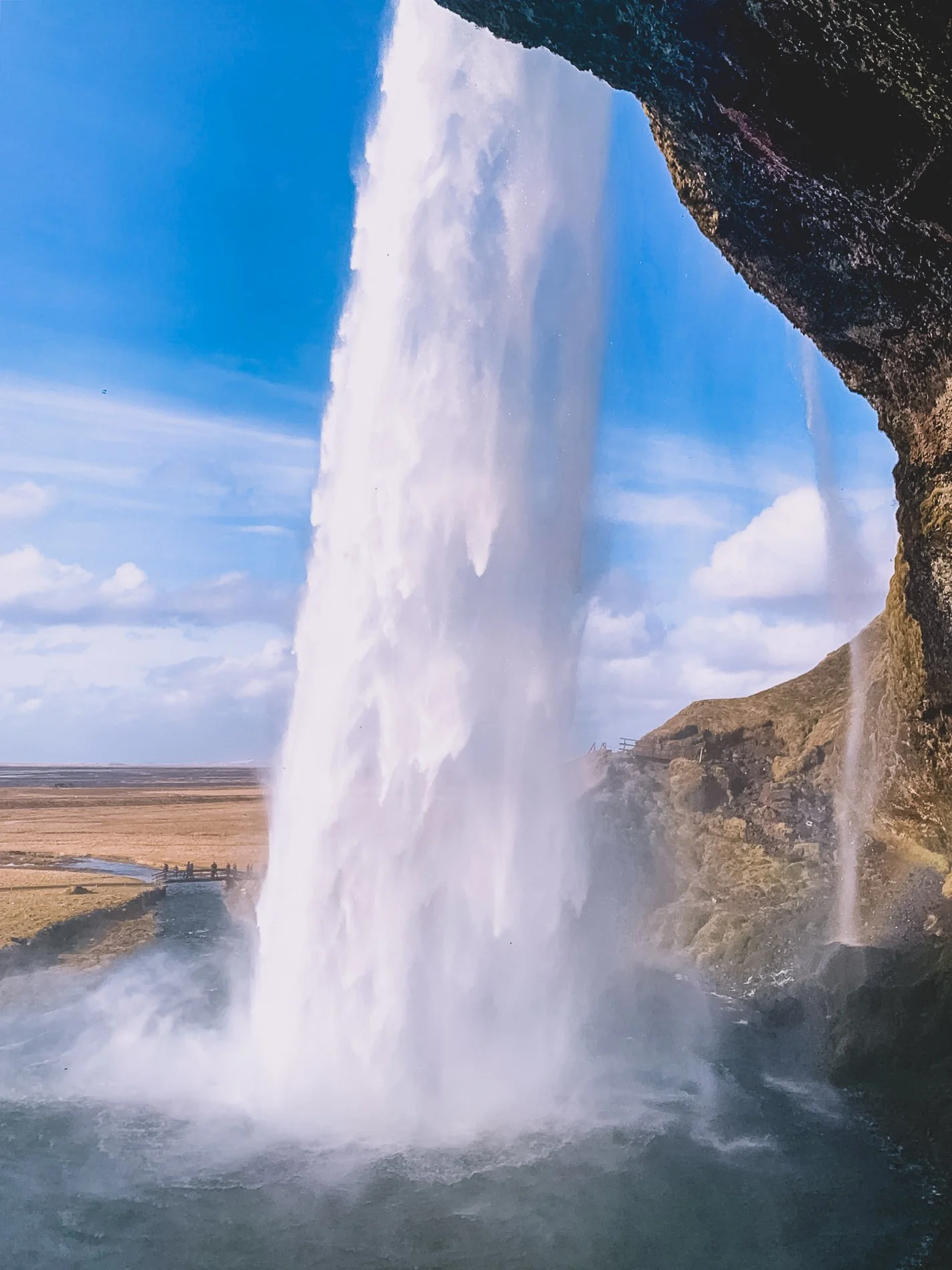 The view from behind Seljelandsfoss waterfall in Iceland.