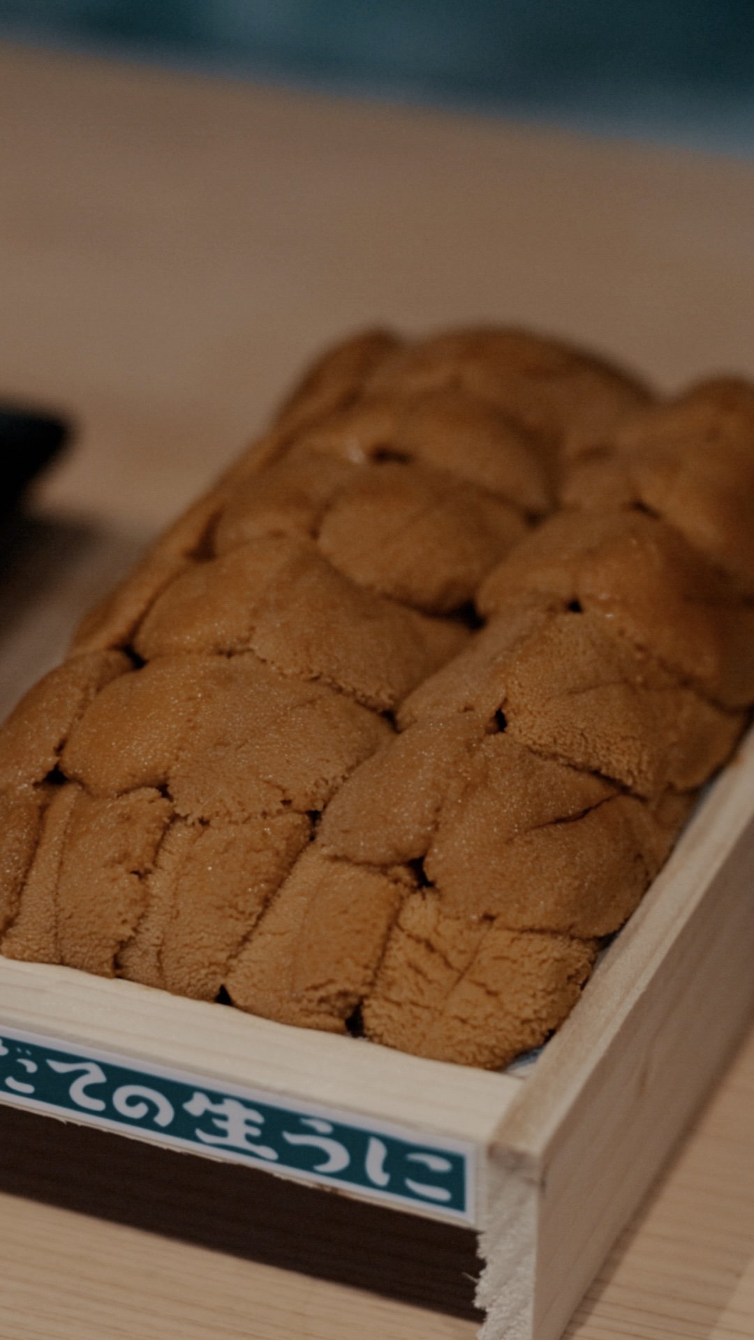 Close-up of a box of Japanese sea urchin (uni) in a wooden container.