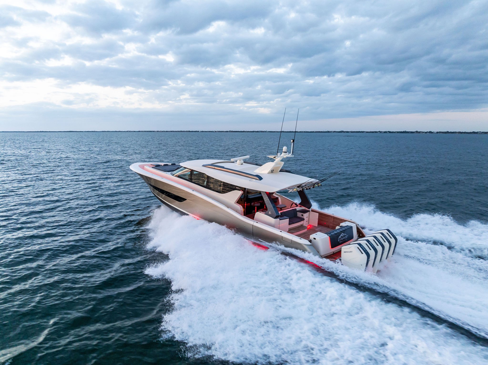 A luxury yacht cruising on the open water under a cloudy sky