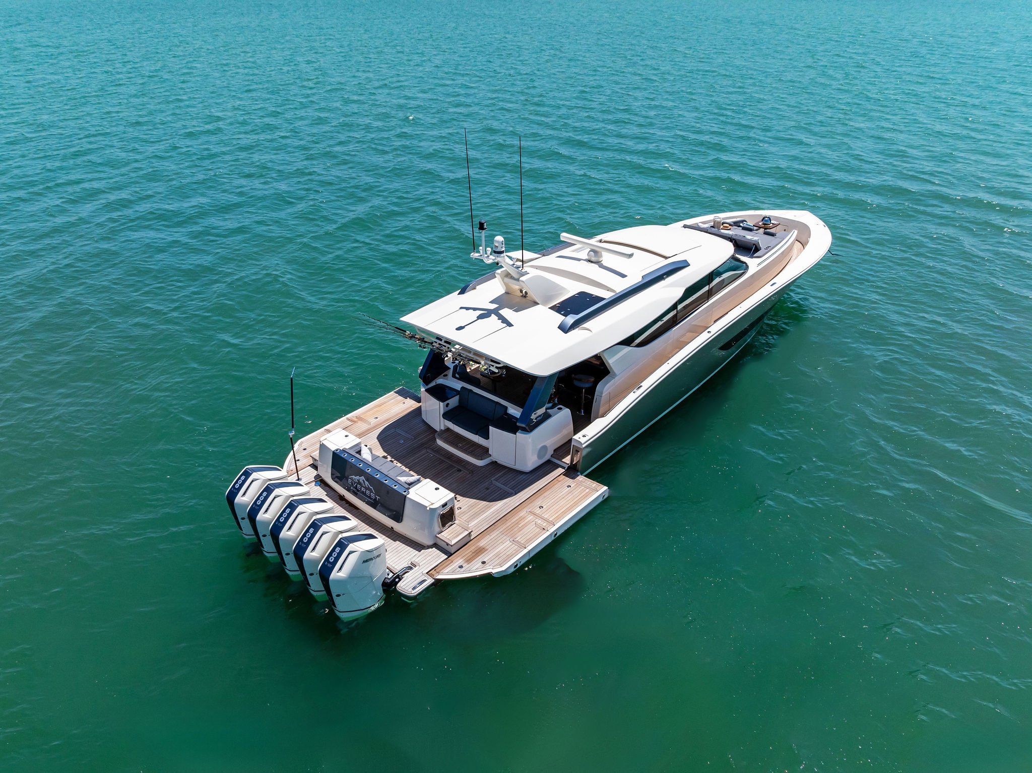 A luxury motor yacht with four outboard engines floating on calm water
