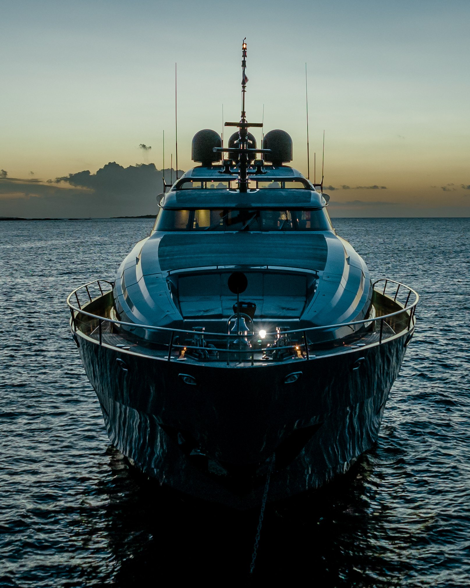 Front view of a yacht on the water at sunset