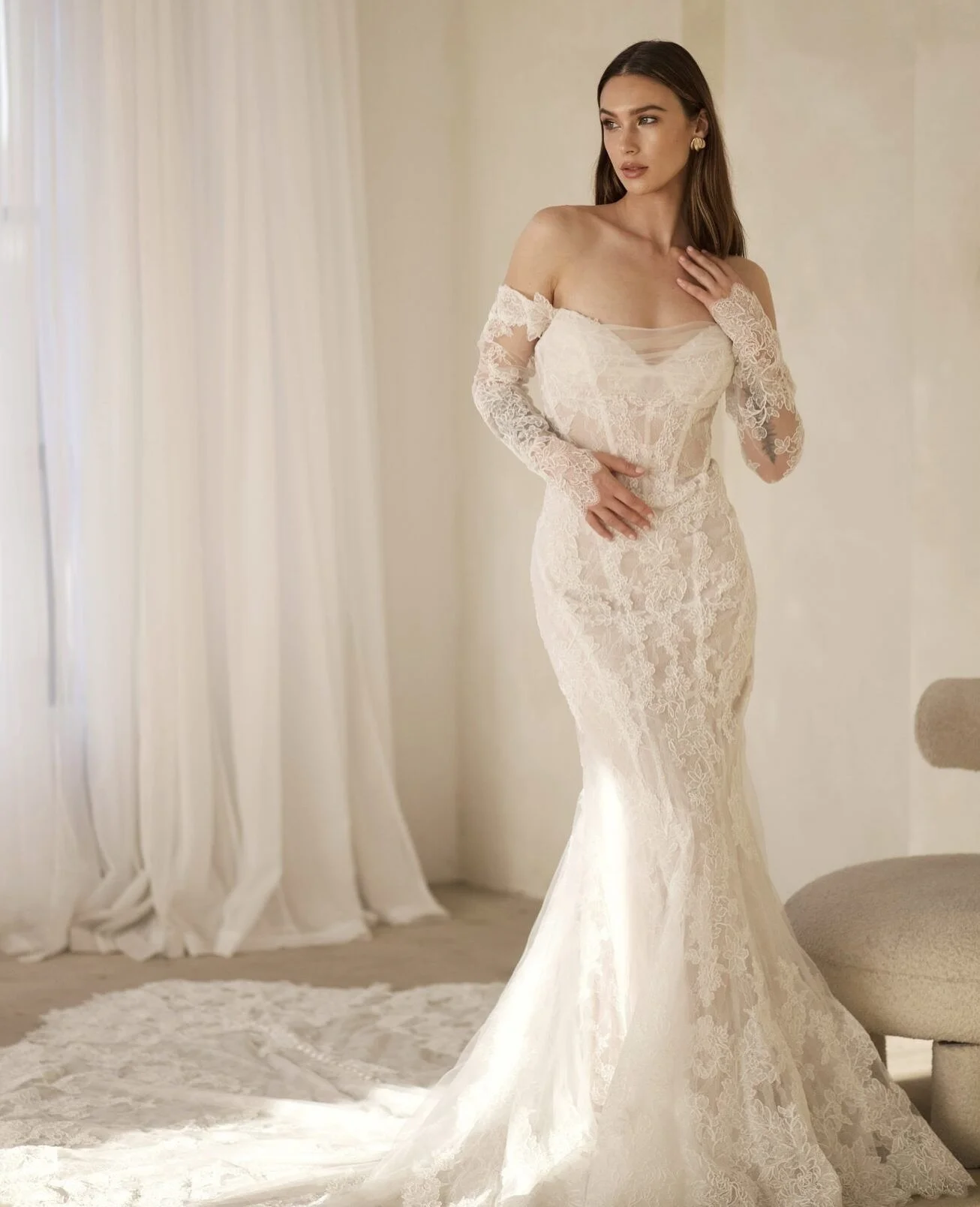 She has met her moment. 🔥 Every detail of these @martinalianabridal looks have us swooning. Detachable sleeves, intricate lace, corset, exposed boning, drop waist&mdash;total main character energy. Jump on over to our website lowsbridal.com to view 