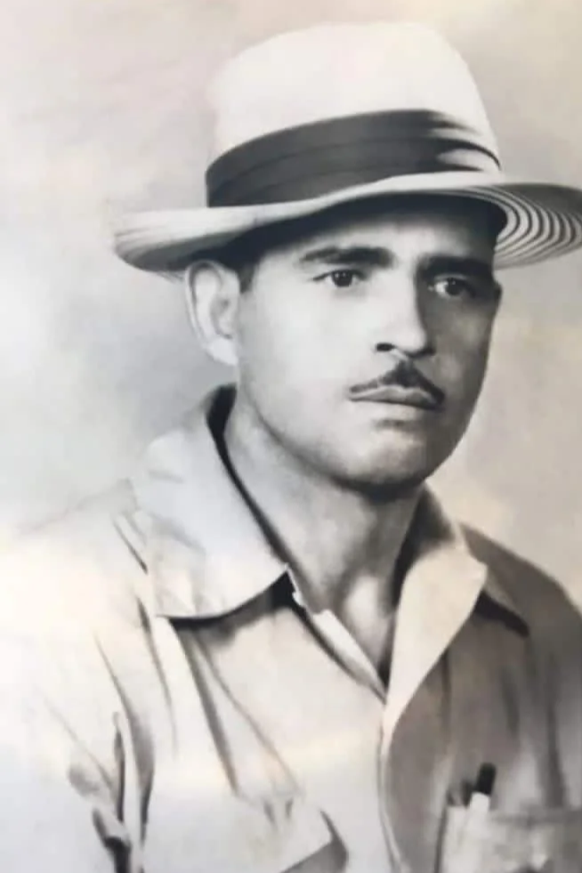 Retrato en blanco y negro de un hombre con bigote, sombrero de ala ancha y camisa, mirando hacia la derecha.