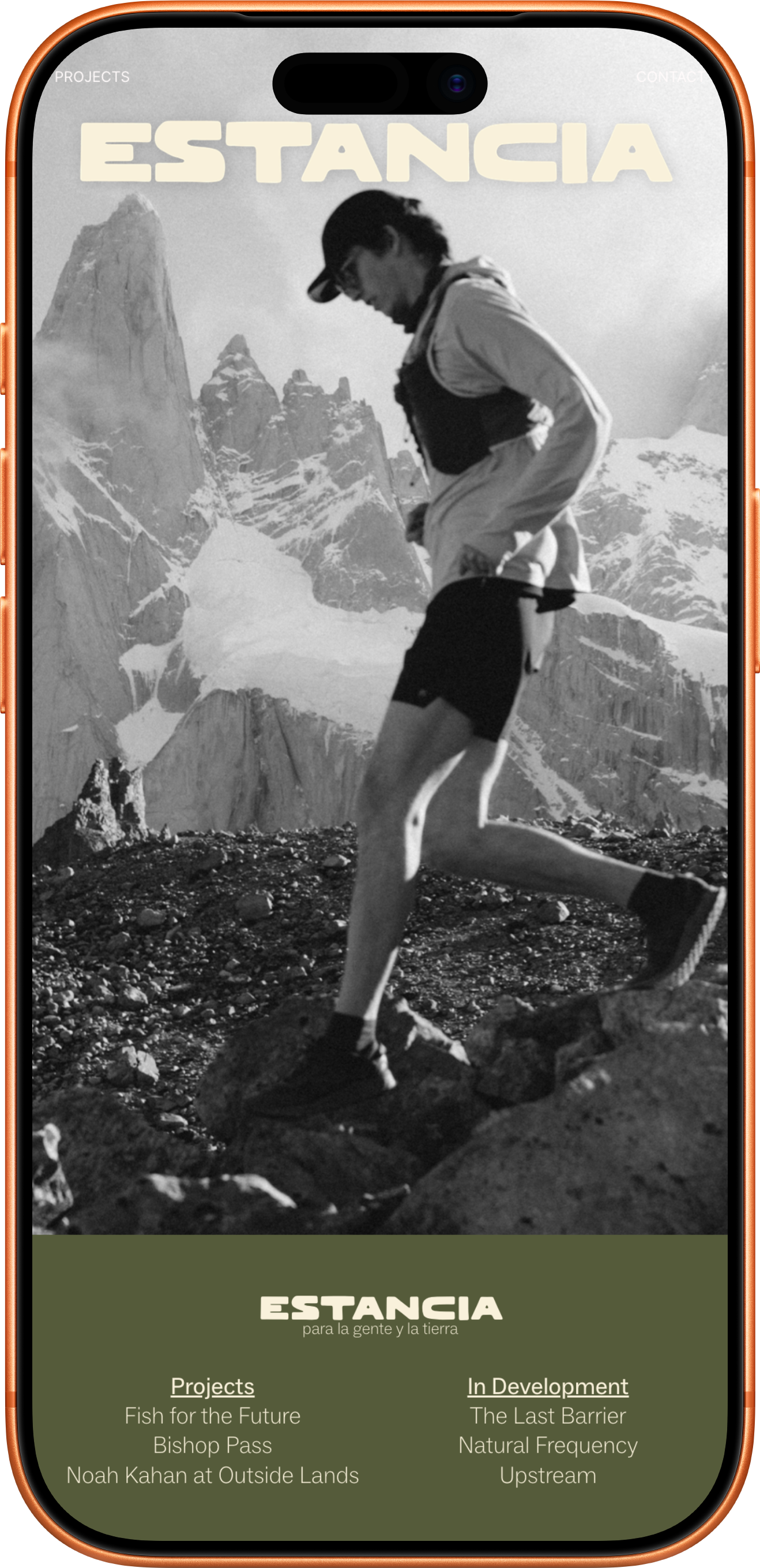 A black and white photo of a person running on rocky terrain in a mountainous snowy landscape.