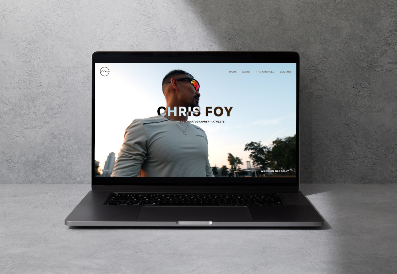 Laptop displaying a website for Chris Foy, a cinematographer and athlete, featuring a profile image of him outdoors wearing sunglasses with trees and sky in the background.
