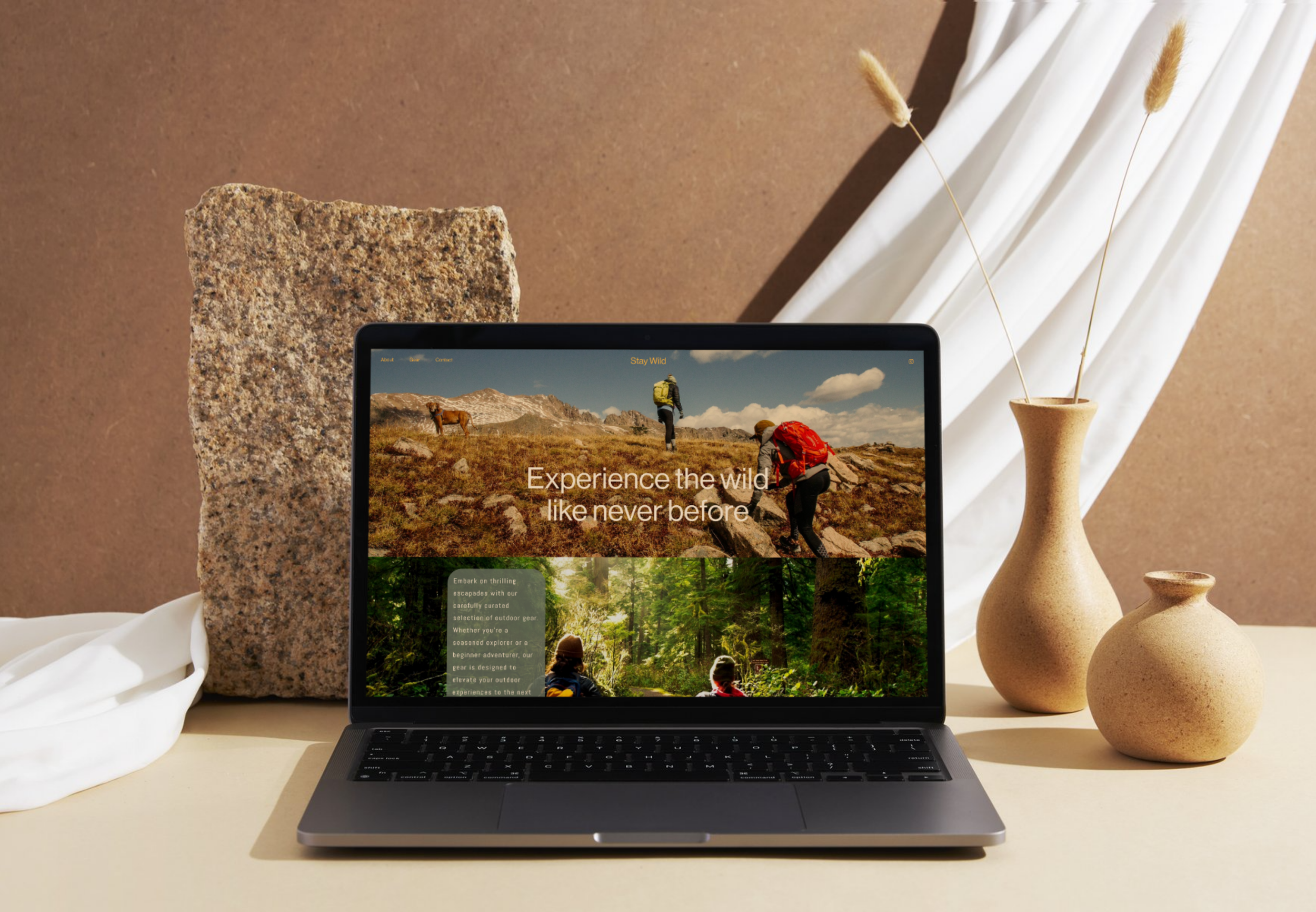 Laptop on a table displaying a website about outdoor adventures, with decorative vases and textured stone and fabric backgrounds.