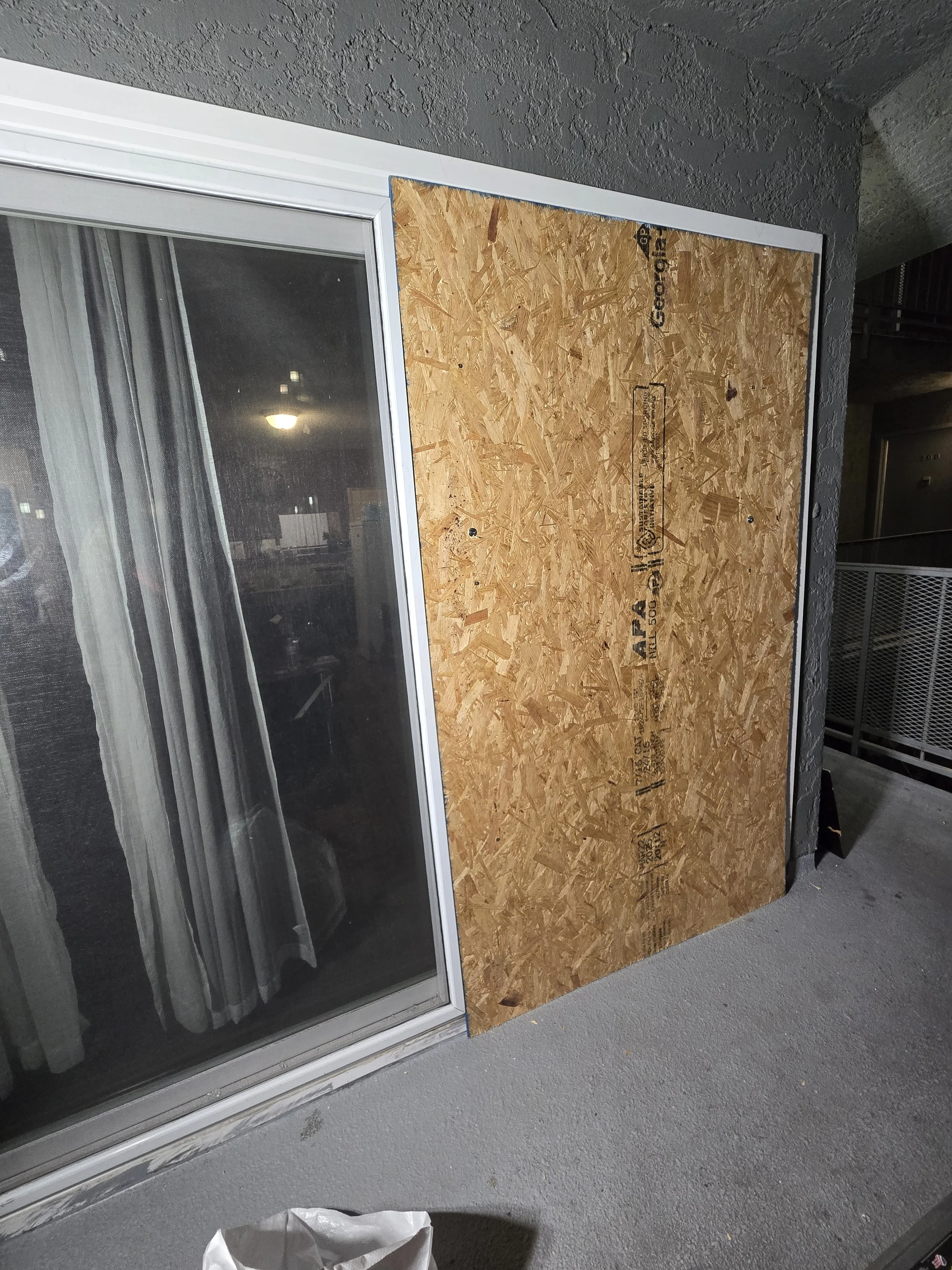 Patio door board-up in Los Angeles — plywood fitted on one sliding 
panel, leaving the intact side untouched. Clean residential install 
by Boardup LA.