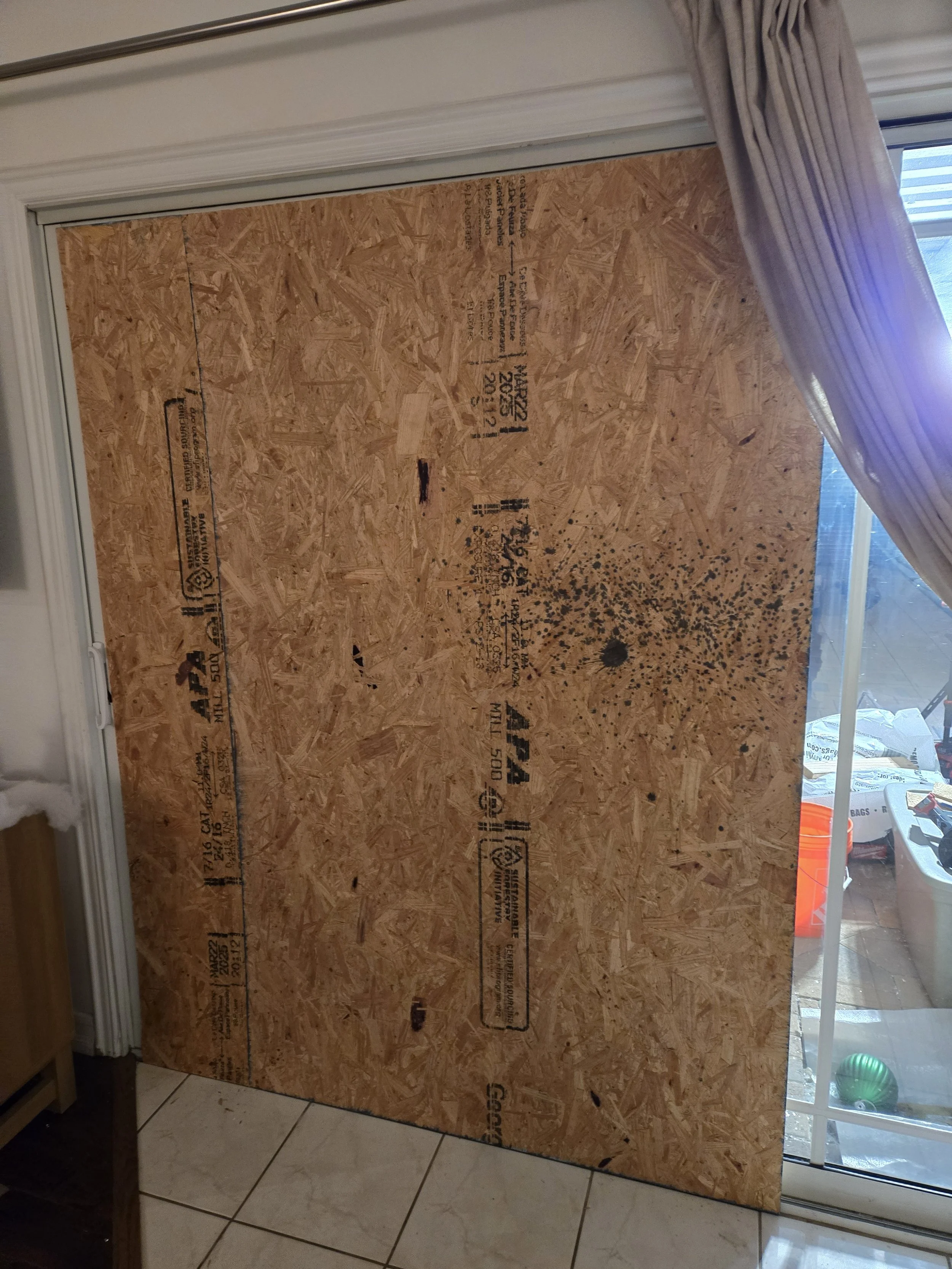 Interior view of residential board-up in Los Angeles — full plywood 
panel sealing a damaged door from inside the home. Secure install 
by Boardup LA.