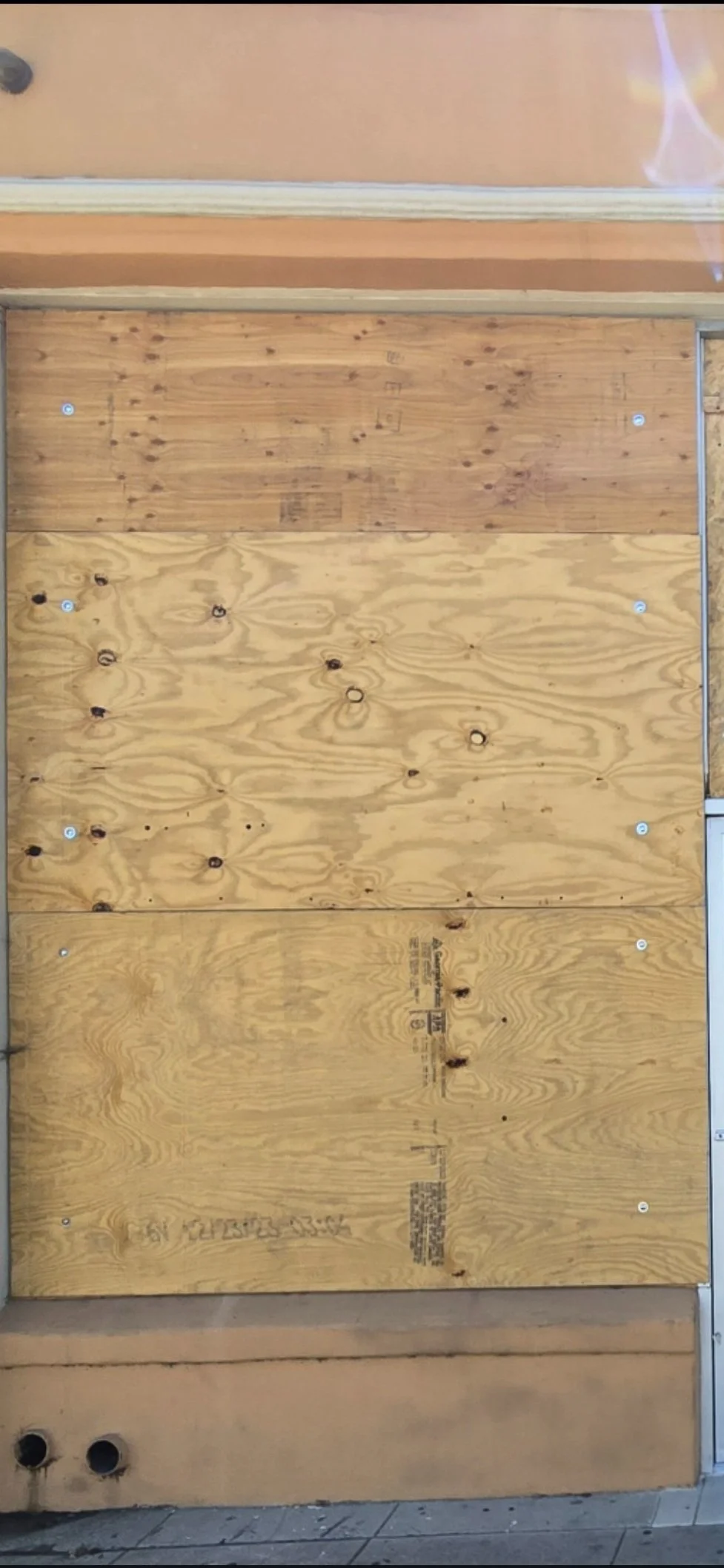 Securing a storefront window with professional OSB plywood board up