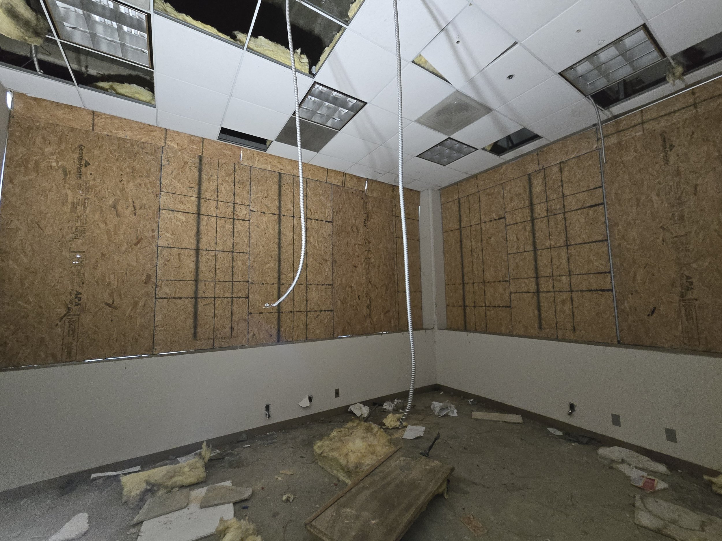 Interior commercial board-up in Los Angeles — full-wall plywood 
panels securing a damaged retail space after major property damage. 
Post-incident service by Boardup LA.