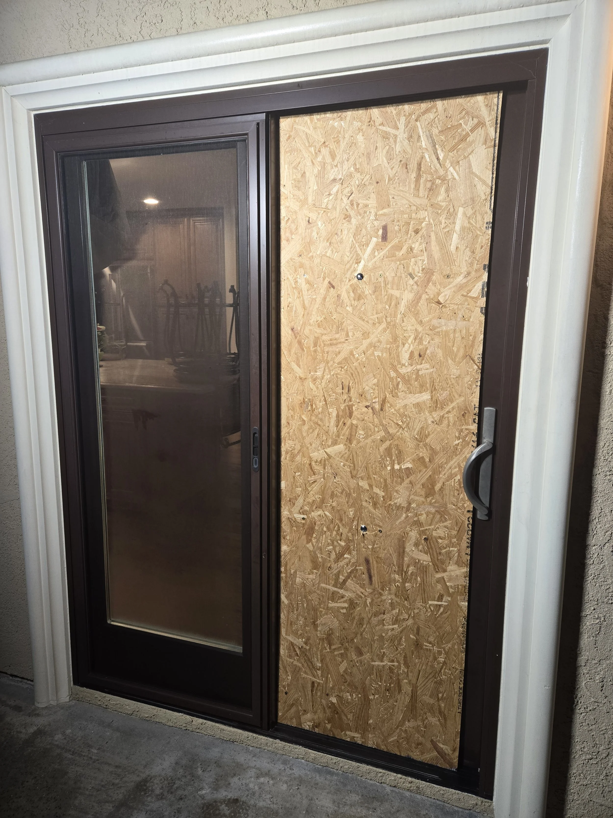 Partial door board-up in Los Angeles — plywood fitted only on the 
damaged panel of a residential double-door entry. Precision work 
by Boardup LA.