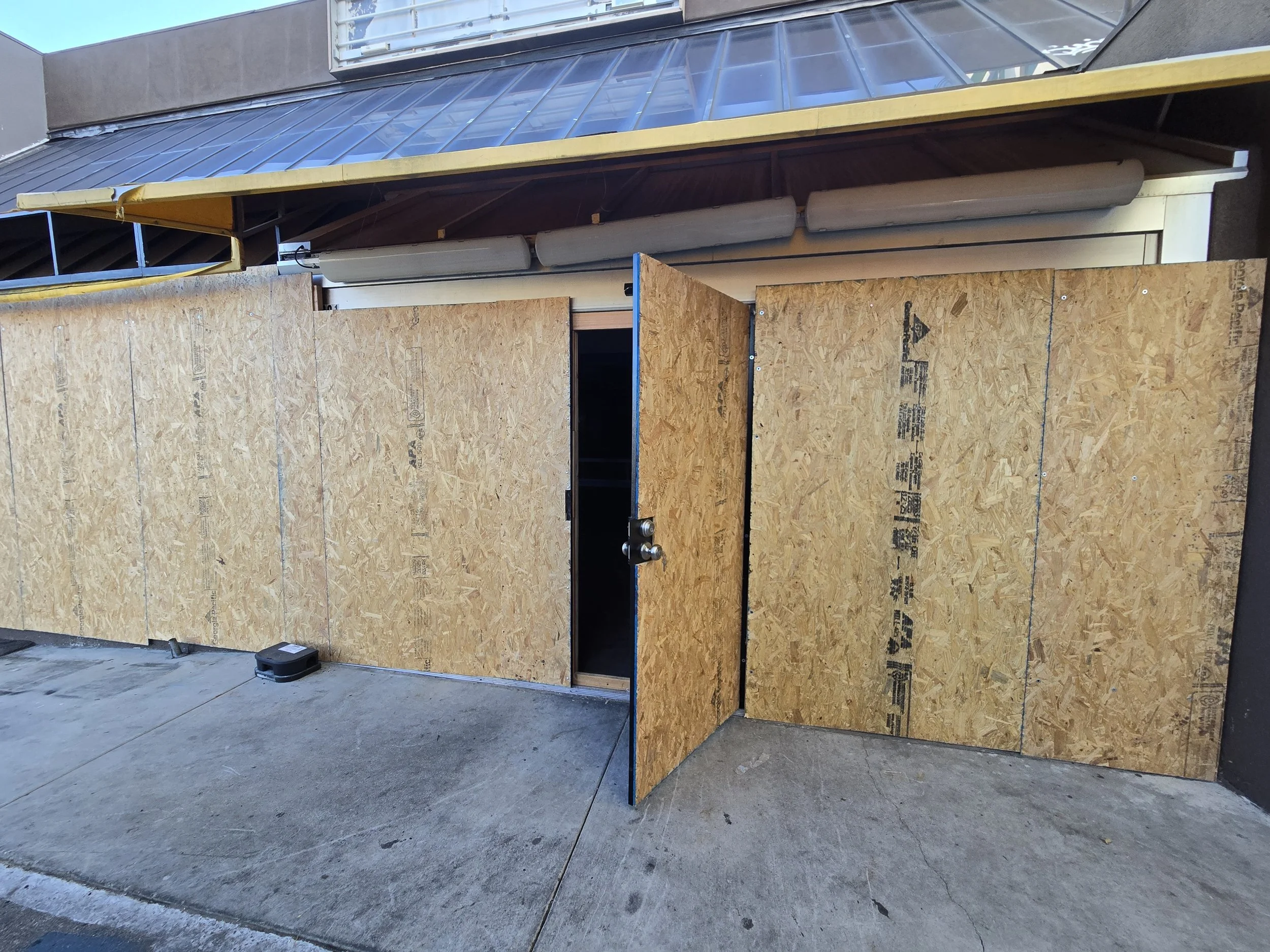 Commercial storefront board-up in Los Angeles — two entry points 
secured with plywood while keeping the main access door operational. 
Emergency board-up after break-in damage by Boardup LA.