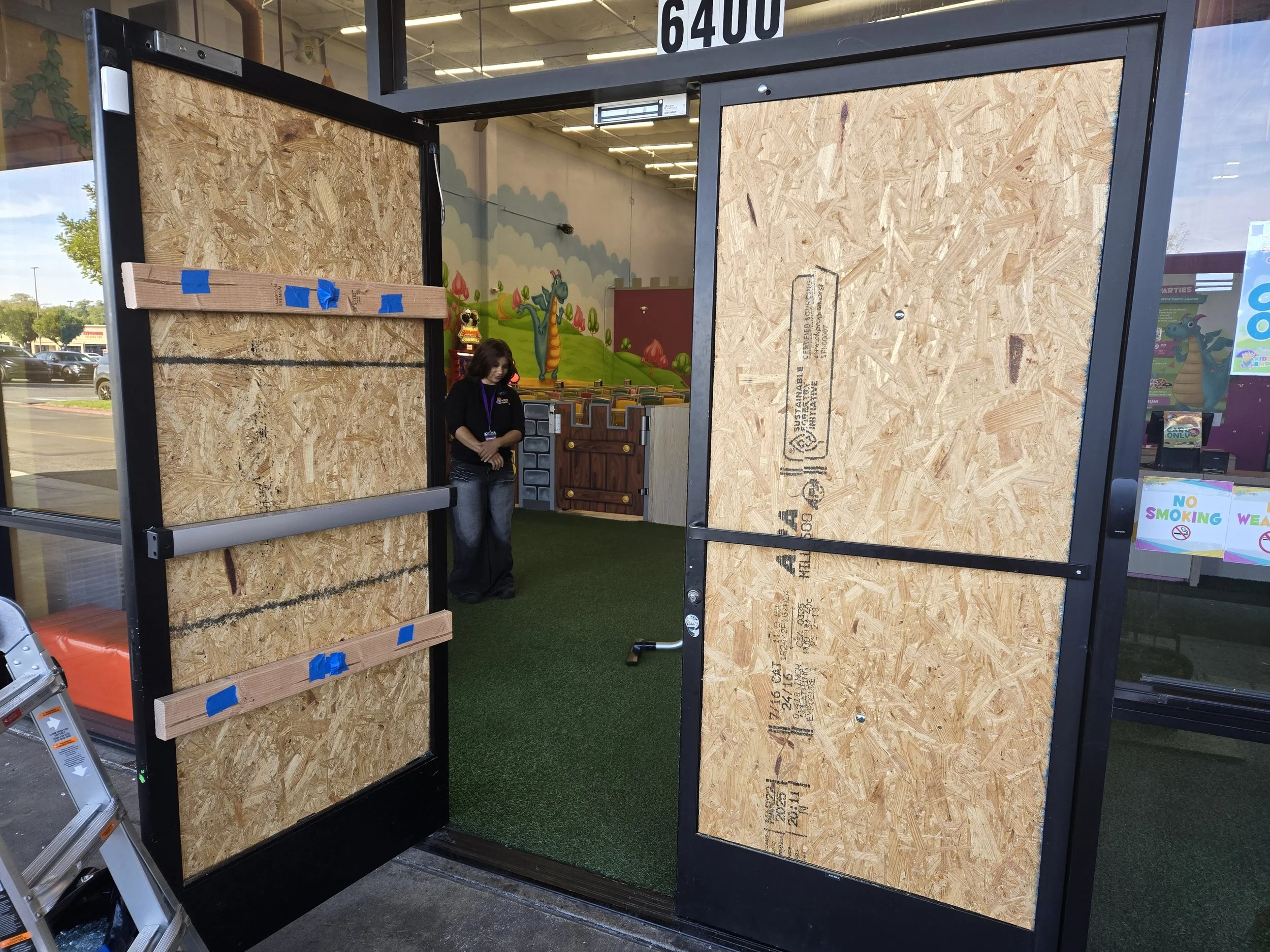 Double-entry commercial board-up in Los Angeles — large plywood 
panels installed on both sides of a storefront entrance during 
active emergency response. Same-day board-up service by Boardup LA's 
on-site crew.