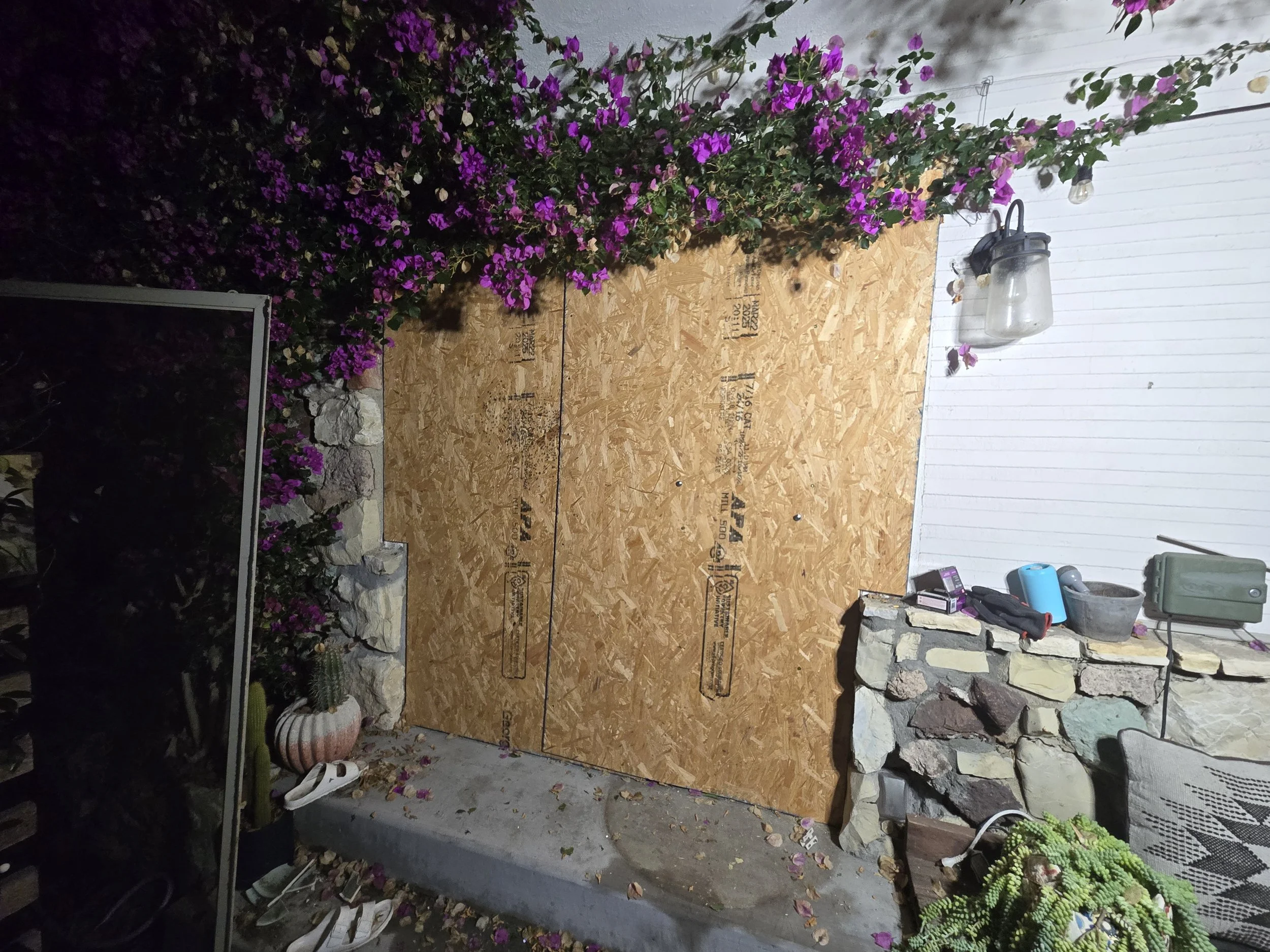 After-hours residential board-up in Los Angeles — plywood securing 
a damaged home entrance late at night. 24/7 emergency response by 
Boardup LA's live crew.