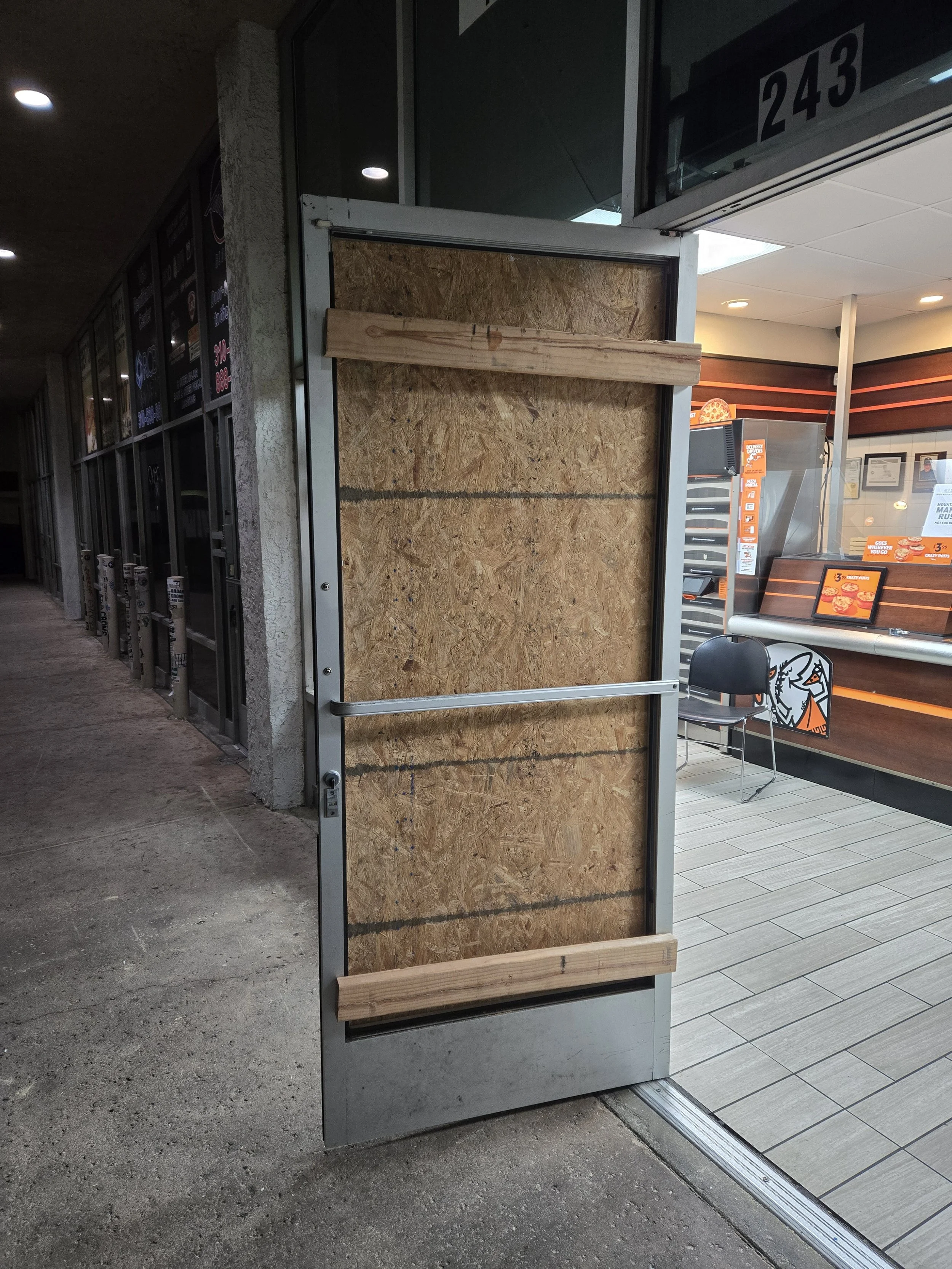 Storefront glass door damage secured with professional board up