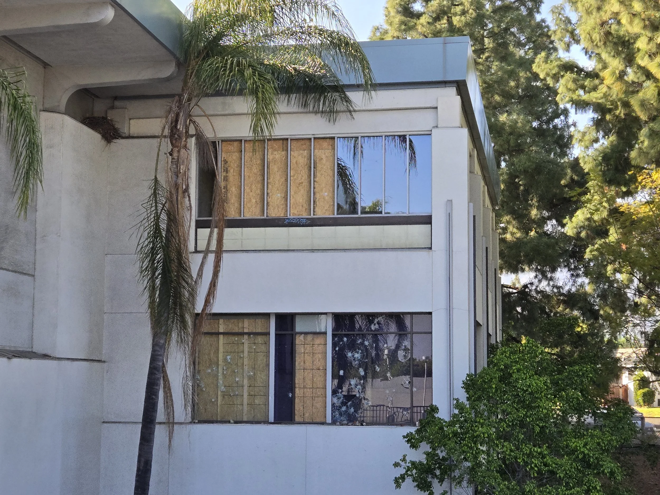 Two-story residential board-up in Los Angeles — plywood securing 
upper and lower unit windows on a building. Multi-floor 
service by Boardup LA.
