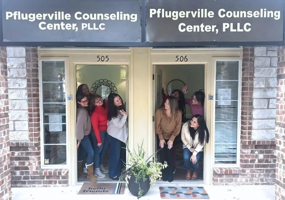 Group of women posing playfully in front of the Pflugerville Counseling Center, PLLC, located at 505 and 506.