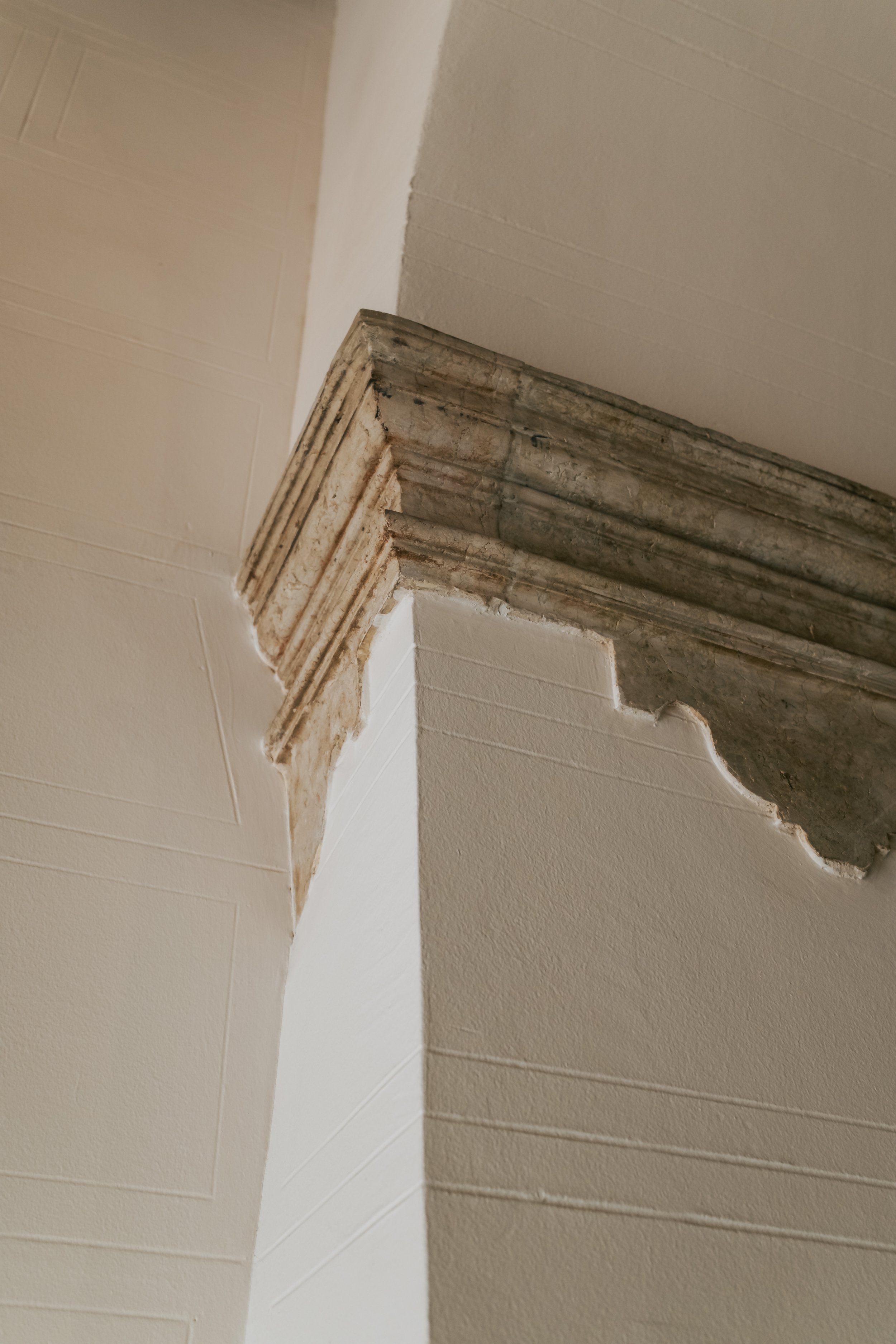 Old architecture with stucco squared columns with concrete trim detail and archway at the top