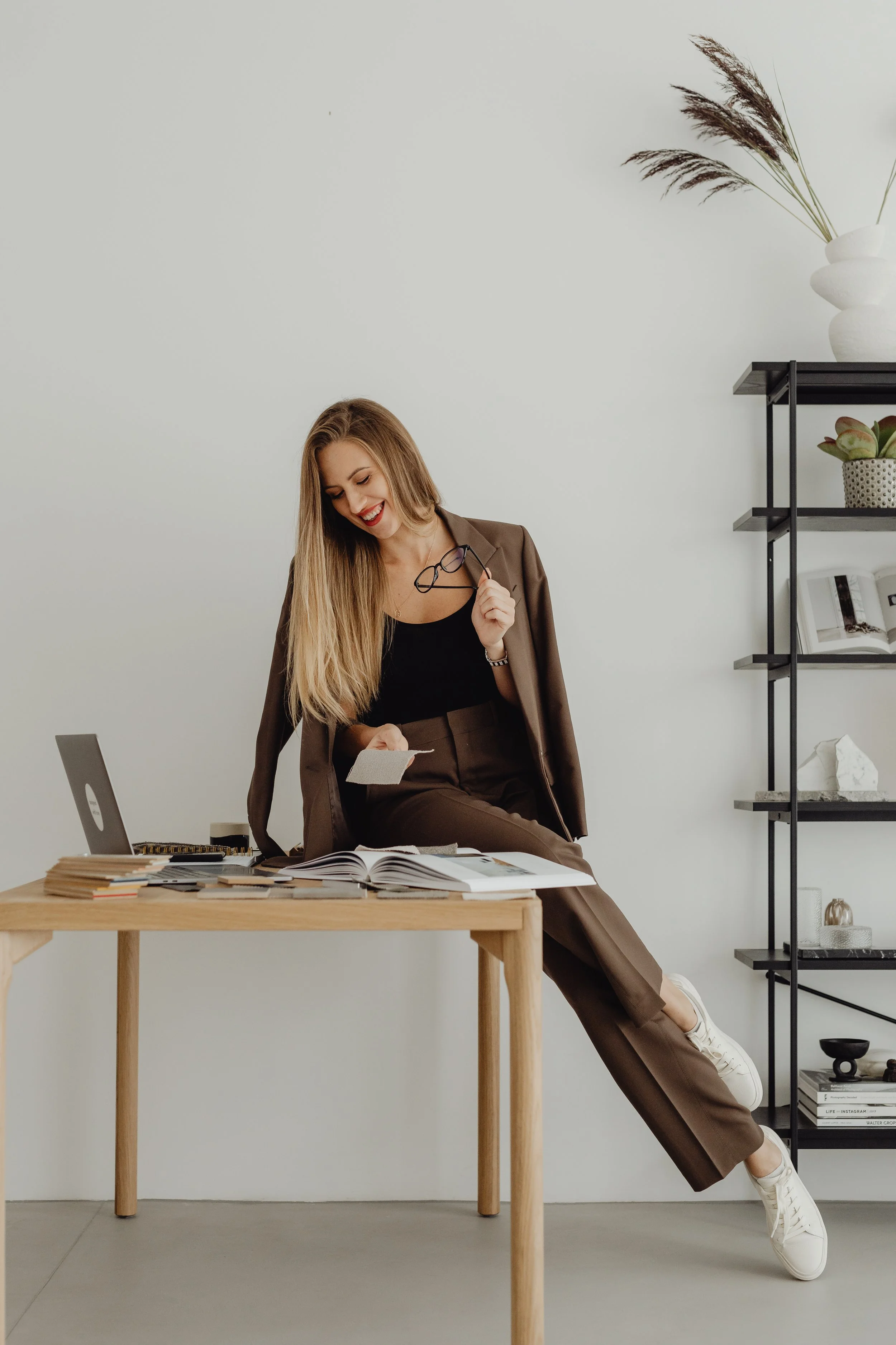 Woman business owner sitting on a table by her laptop working