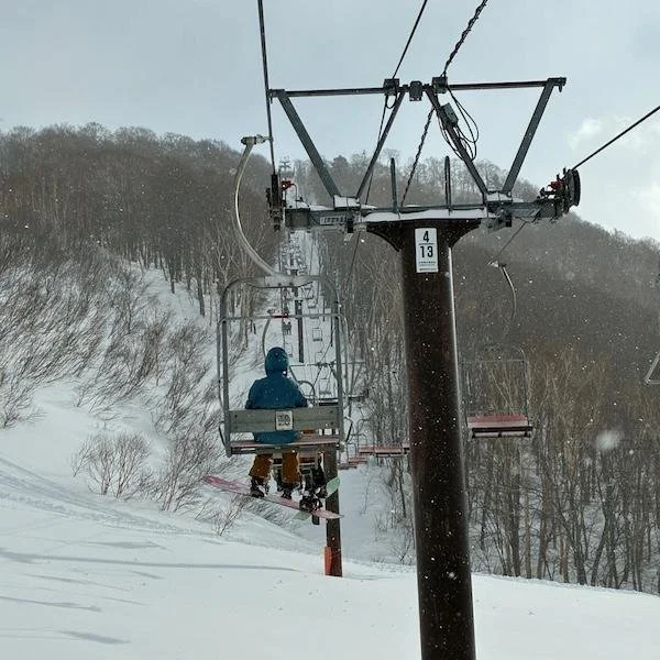 snowboarder on chairlift tsugaike