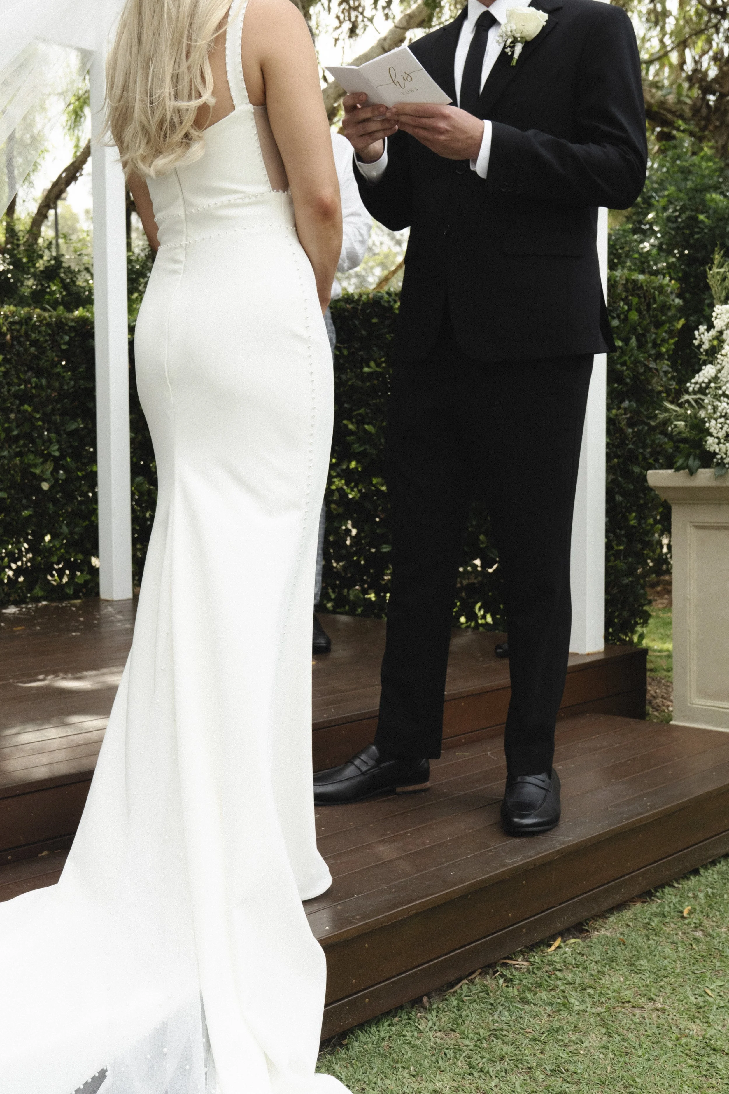 Bride and groom exchanging vows at an outdoor wedding ceremony - Elevated Weddings