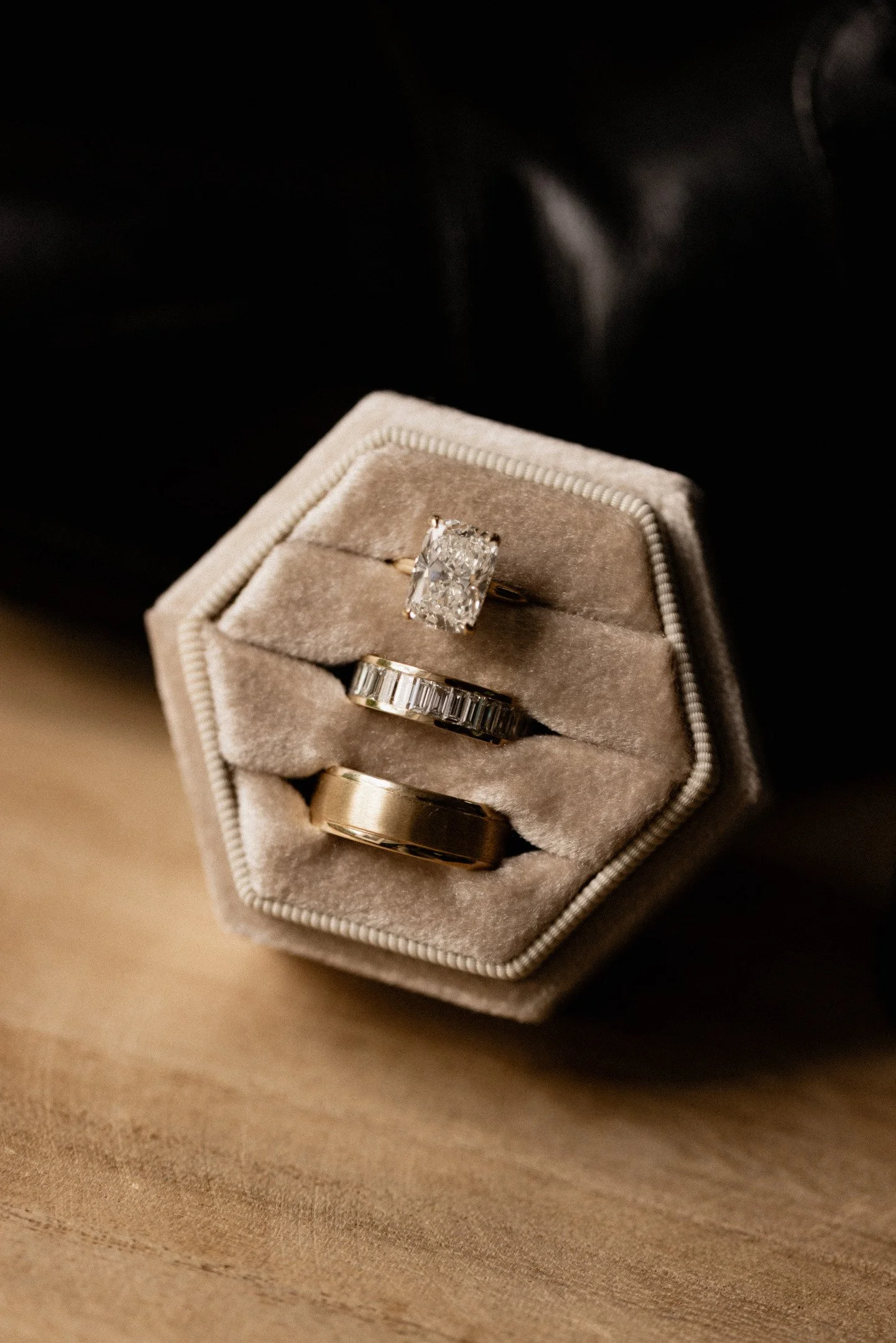 Close-up of a jewelry box containing three rings with a black background.