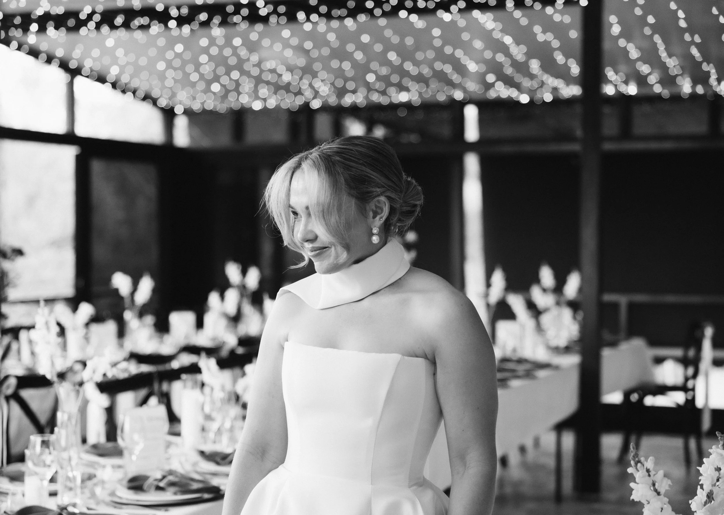 Woman in a wedding dress standing in a decorated venue -Elevated Weddings