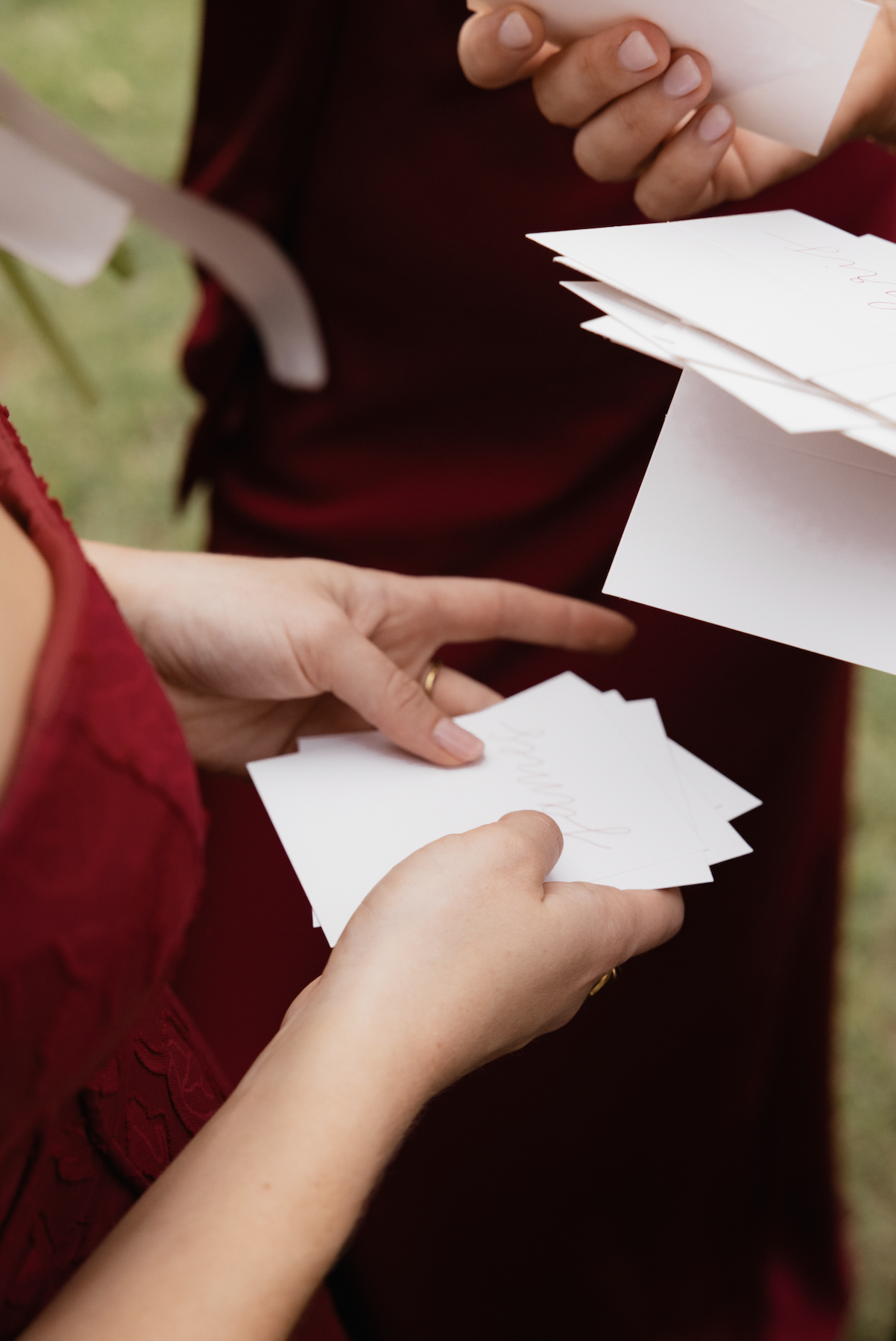 Two people exchanging or holding handwritten notes or cards during an outdoor event.