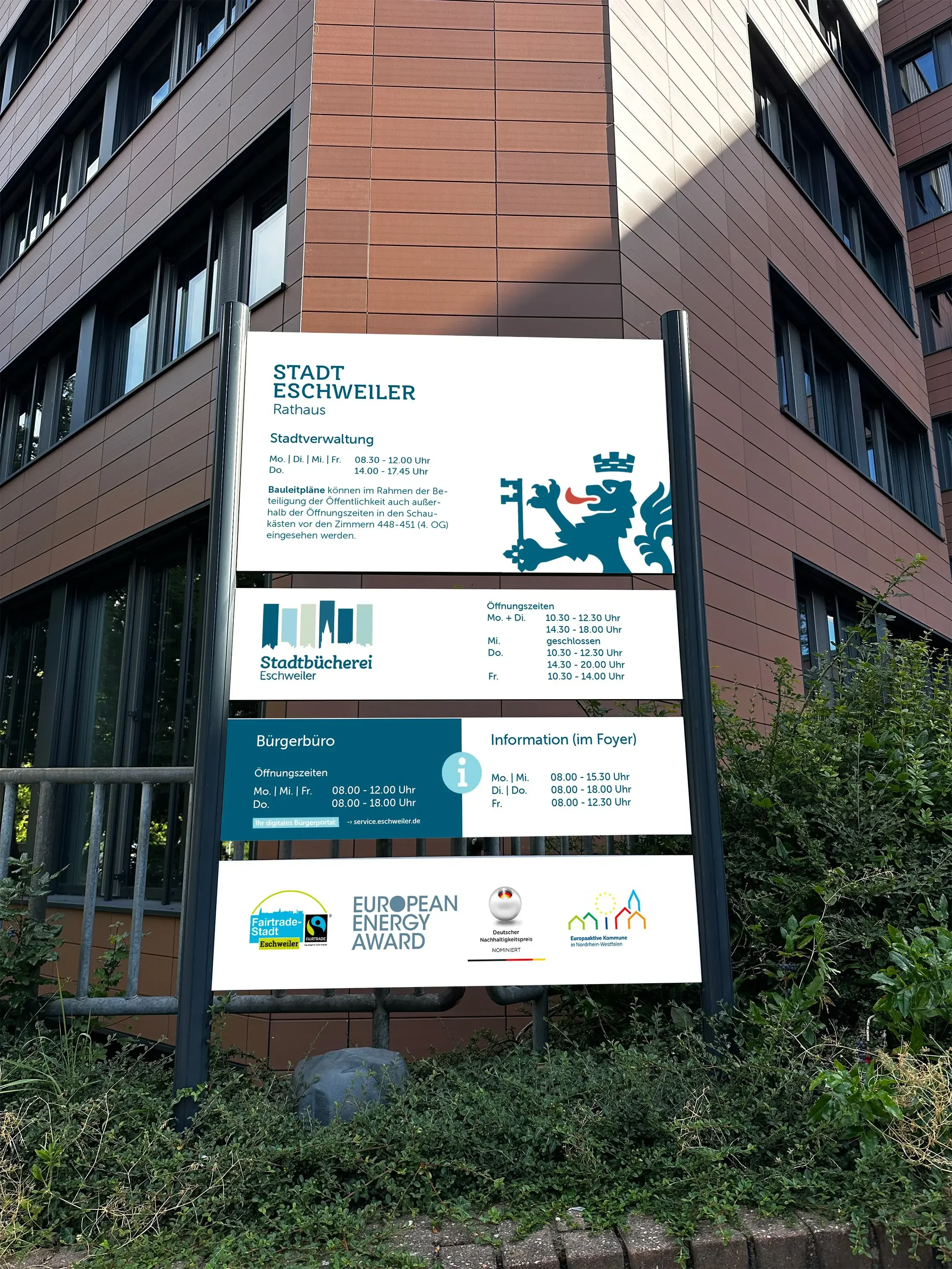 Gebäude der Stadtverwaltung Eschweiler im Vordergrund Schild mit diversen Ämtern