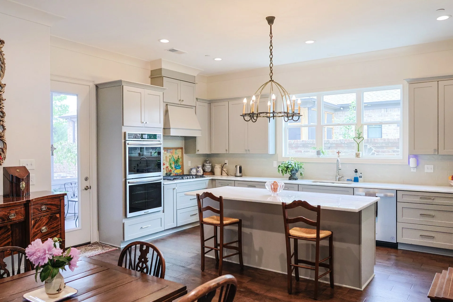 naturally lit kitchen with custom cabinet and quartz countertop island.