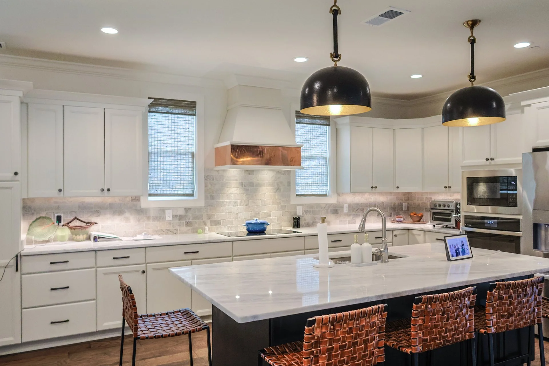 kitchen quartz countertops and under cabinet lights with copper accented exhaust